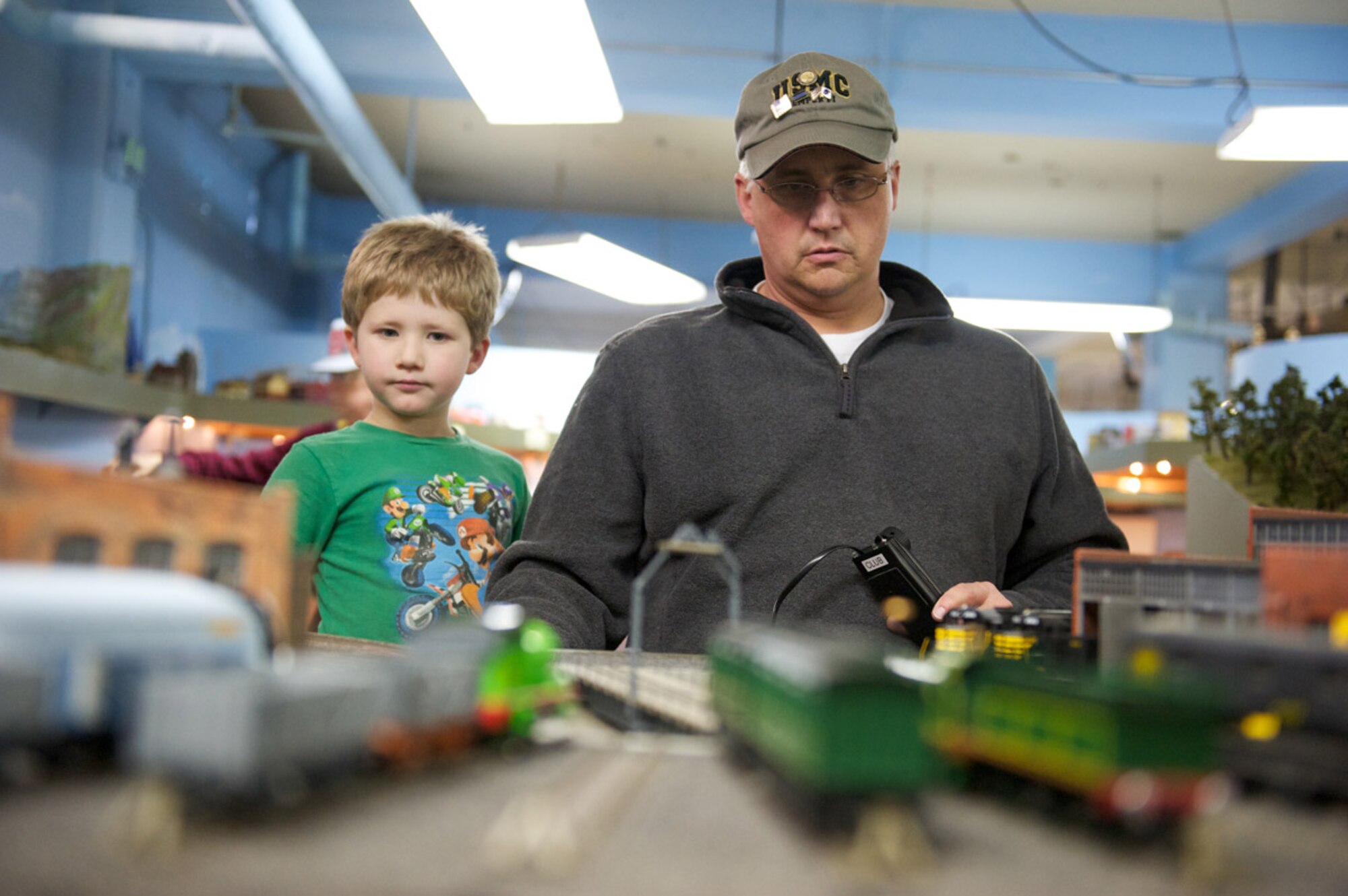 Lance Parcell, Military Society of Model Railroad Engineers club member, controls a scale model roundhouse, Nov. 20, at Matanuska Hall with 6-year-old son Zachary. MSMRE operates several different layouts in different scales, all made with meticulous detail. (Photo by David Bedard/JBER PAO)