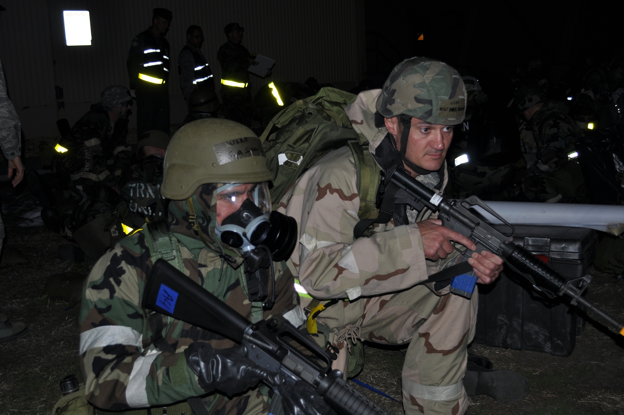 TRAVIS AIR FORCE BASE, Calif. -- Armed Airmen take up protective posture outside a simulated bunker where 349th AMW personnel have bugged out after their building is set on fire by a missile attack. Reserve Airmen manned 12-hour night shifts, while 60th AMW Airmen worked 12-hour days during the base exercise, so they could
realistically prepare for the January 2013 operational readiness inspection.
(U.S. Air Force photo/Senior Master Sgt. Ellen Hatfield)