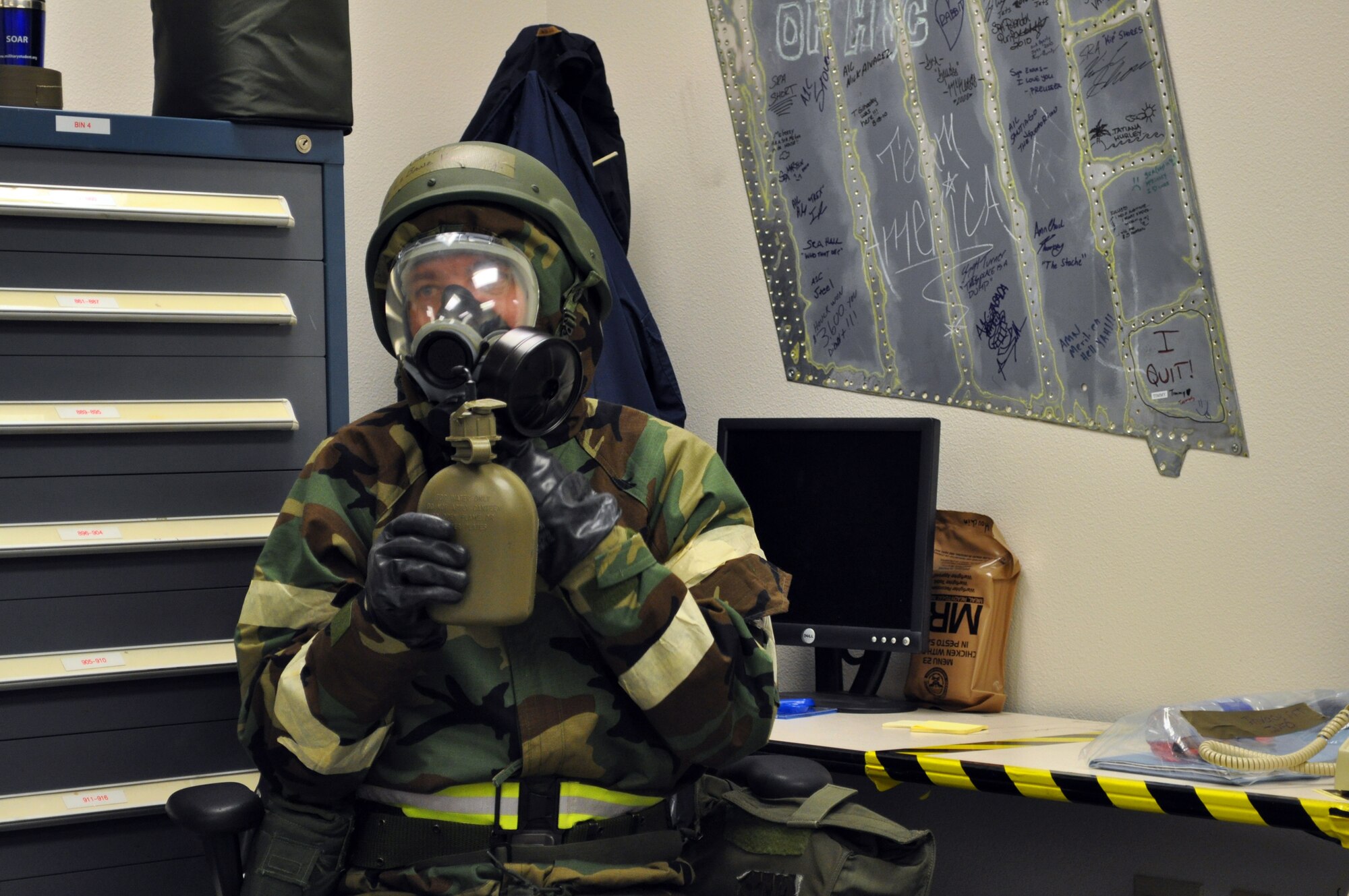 TRAVIS AIR FORCE BASE, Calif. -- 349th AMW Chaplain, (Lt. Col.) LaBane Hall demonstrates his ability to drink water through a tube while hunkered down in Mission Oriented Protective Posture level 4 during Exercise Crisis Look 10-07. More than 650 Airmen assigned to both the Reserve's 349th AMW and the 60th AMW spent a week,
working round the clock, to practice their ability to survive and operate in an austere location, in preparation for the next operational readiness inspection. One of the most important lessons is to drink plenty of water to combat dehydration. (U.S. Air Force photo/Senior Master Sgt. Ellen Hatfield)