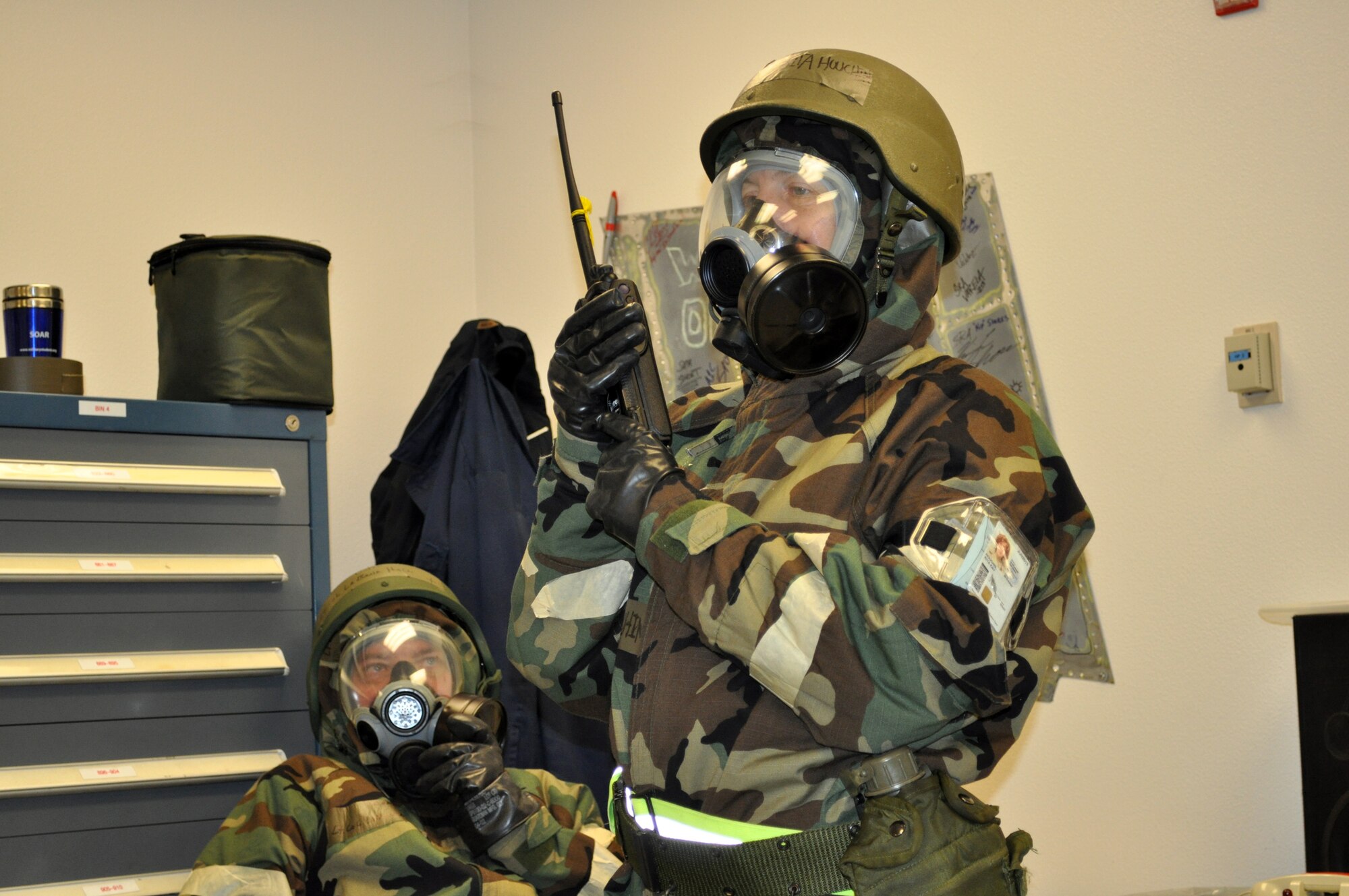TRAVIS AIR FORCE BASE, Calif. -- 349th AMW Chaplain assistant, Master Sgt. Rita Houchin, listens to radio communications during Exercise Crisis Look, Nov. 1-7, 2010. Both she and Chaplain (Lt. Col.) LaBane Hall, seated, had just entered Mission Oriented Protective Posture level 4, which includes all their individual protective equipment that defends them against nuclear, biological, chemical and conventional hazards. (U.S. Air Force photo/Senior Master Sgt. Ellen Hatfield)