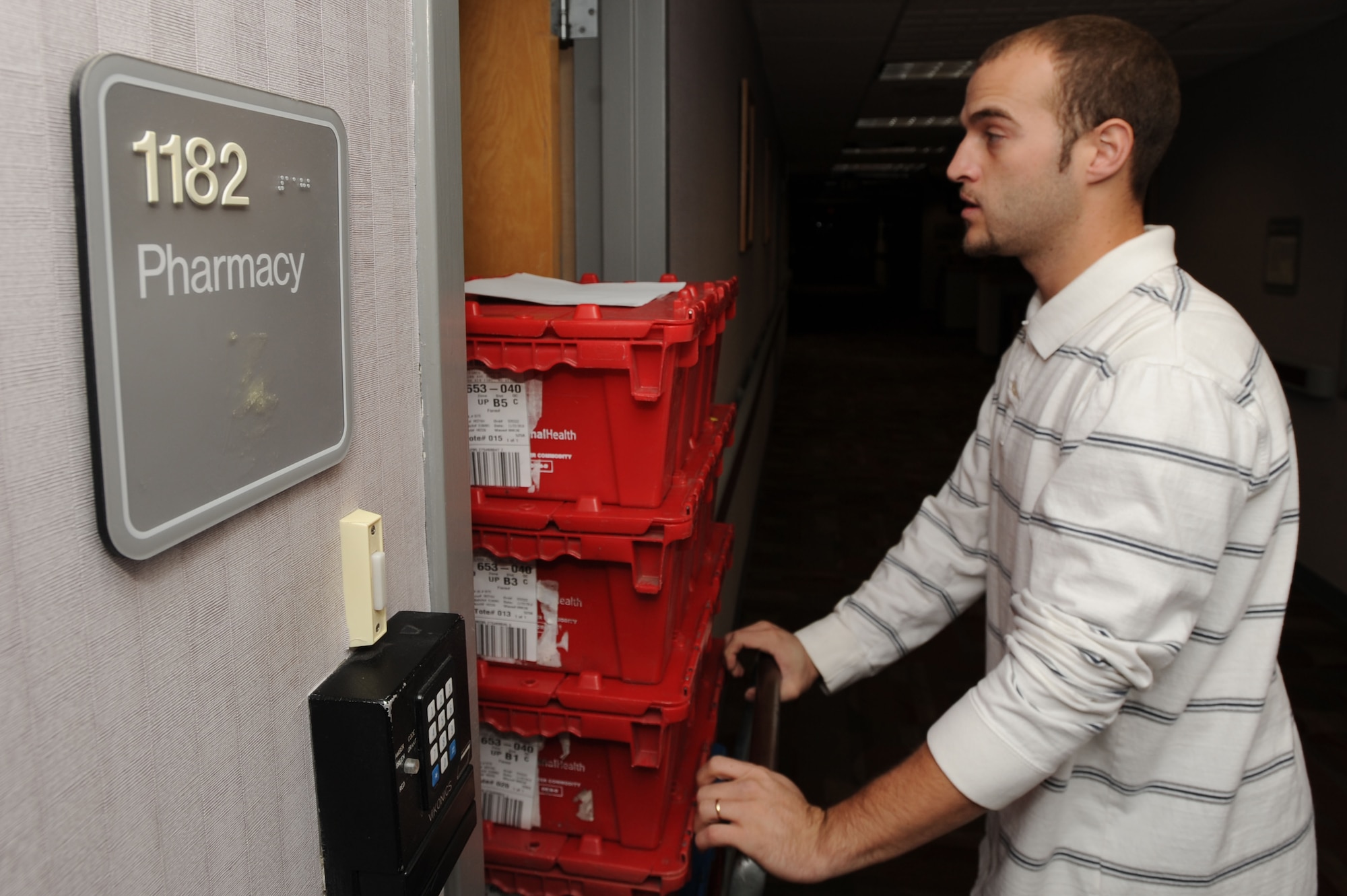 WHITEMAN AIR FORCE BASE, Mo. - Shane Huntsman, 509th Medical Support Squadron medical logistics technician, delivers the daily shipment of pharmaceutical supplies to the 509th Medical Group pharmacy here, Nov. 23. The shipment is logged into the system by a technician after it arrives.(U.S. Air Force photo by Senior Airman Carlin Leslie)

