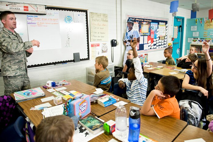 NELLIS AIR FORCE BASE, Nev.-- Airman 1st Class Timothy Bass, an engineering assistant with the 99th Civil Engineer Squadron Geo Base office, explains to a fifth grade class at Lomie G. Heard Elementary School how satellites orbiting the earth provide information to global positioning systems Nov. 17 as part of the annual Geography Awareness Week. Members from the 99 CES shared their knowledge with students and explained the impact GIS technology is making in our daily lives. (U.S. Air Force photo/ Lawrence Crespo)