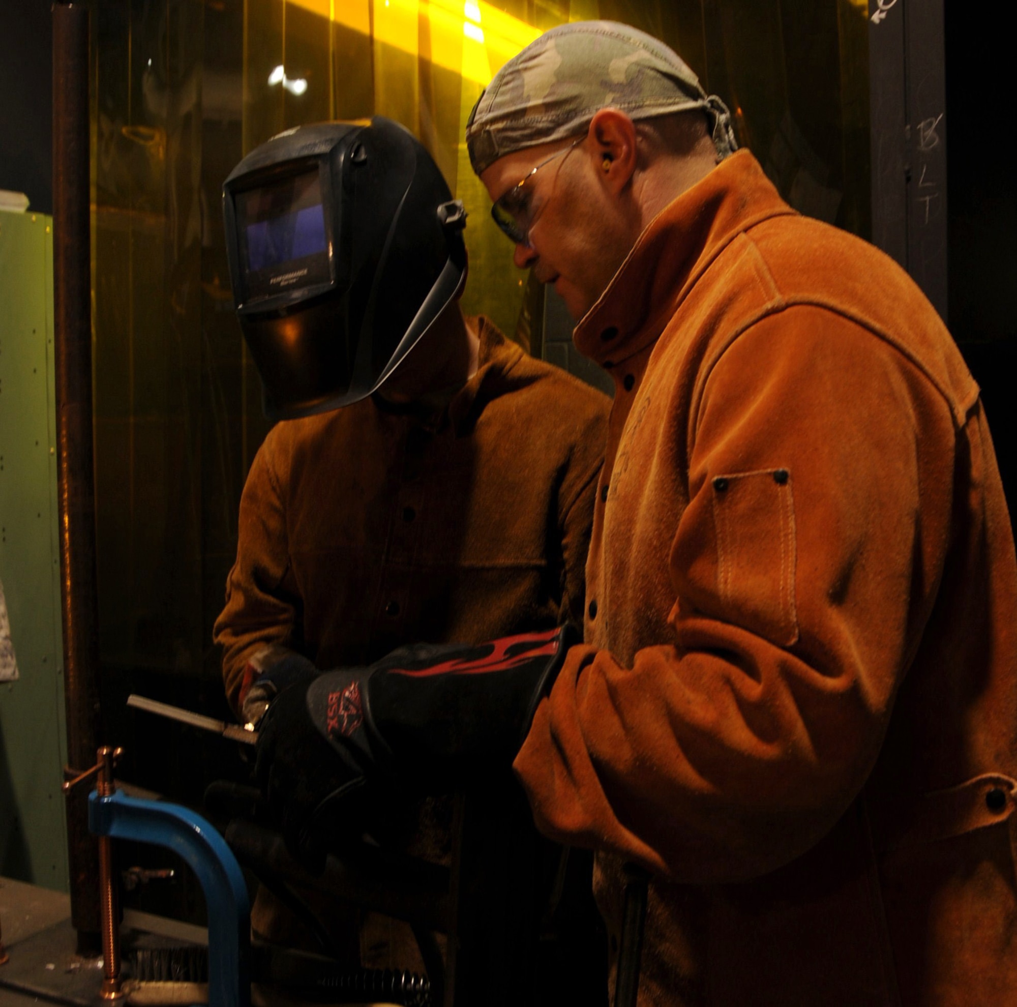Sergeant Human evaluates a student’s completed weld. He checks to make sure the bead has gone through pieces of metal completely and that the weld was completed in no more than three passes. (Photo by Airman 1st Class Heather Holcomb)
