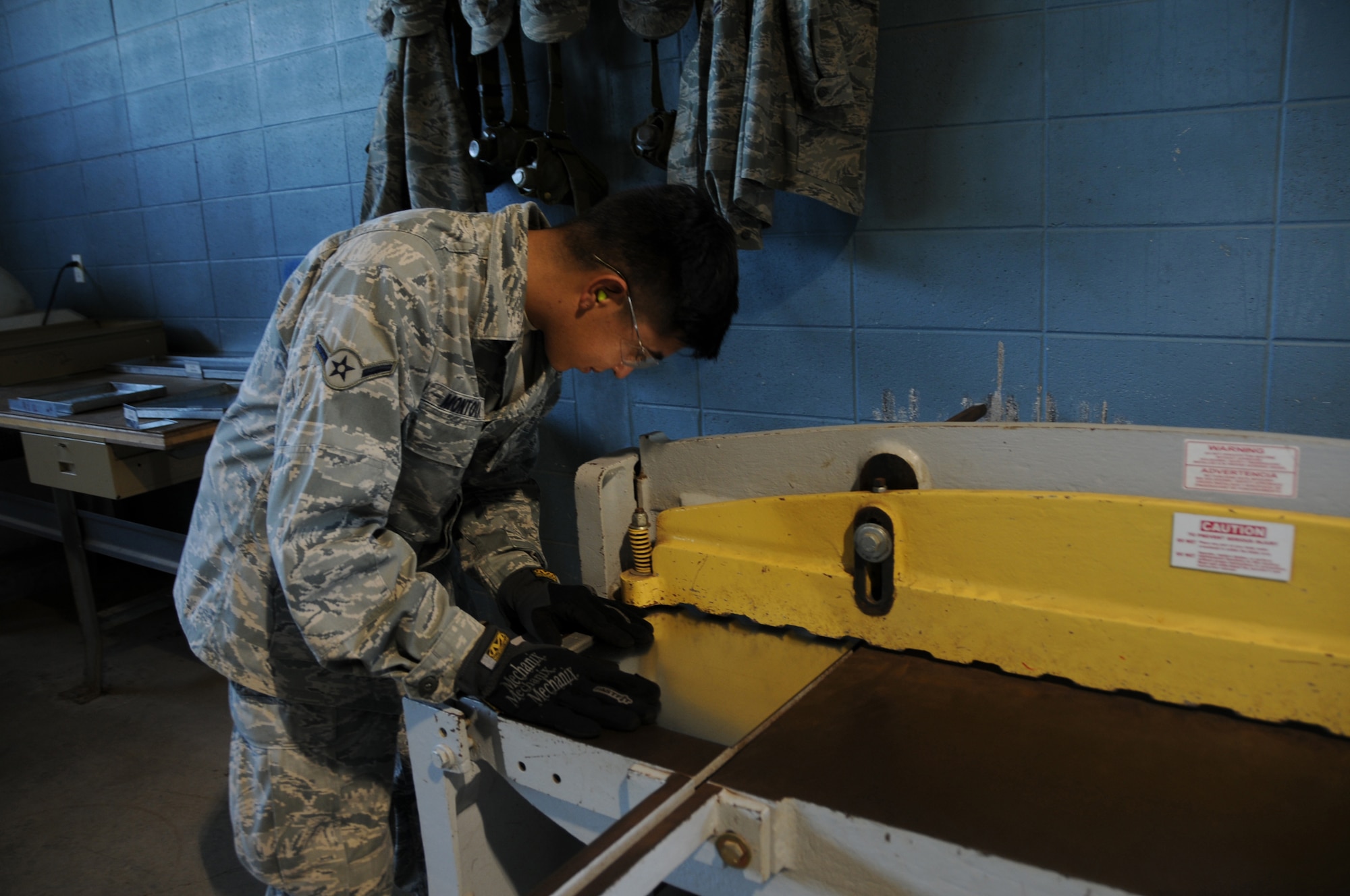 Airman Oscar Montoya cuts sheet metal to make a model air conditioning duct. (Photo by Airman 1st Class Heather Holcomb)