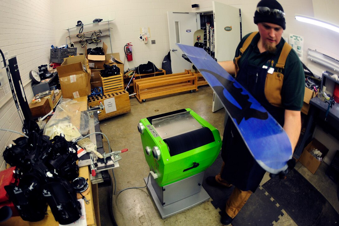 ELLSWORTH AIR FORCE BASE, S.D. - Nate Miller, 28th Force Support Squadron Outdoor Recreation shop technician, inspects the base of a snowboard for a proper wax coating after waxing and buffing, Nov. 22.  For more information about the services provided by Outdoor Rec. visit http://www.ellsworthfss.com/outdoor-recreation. (U.S. Air Force photo/Staff Sgt. Marc I. Lane)