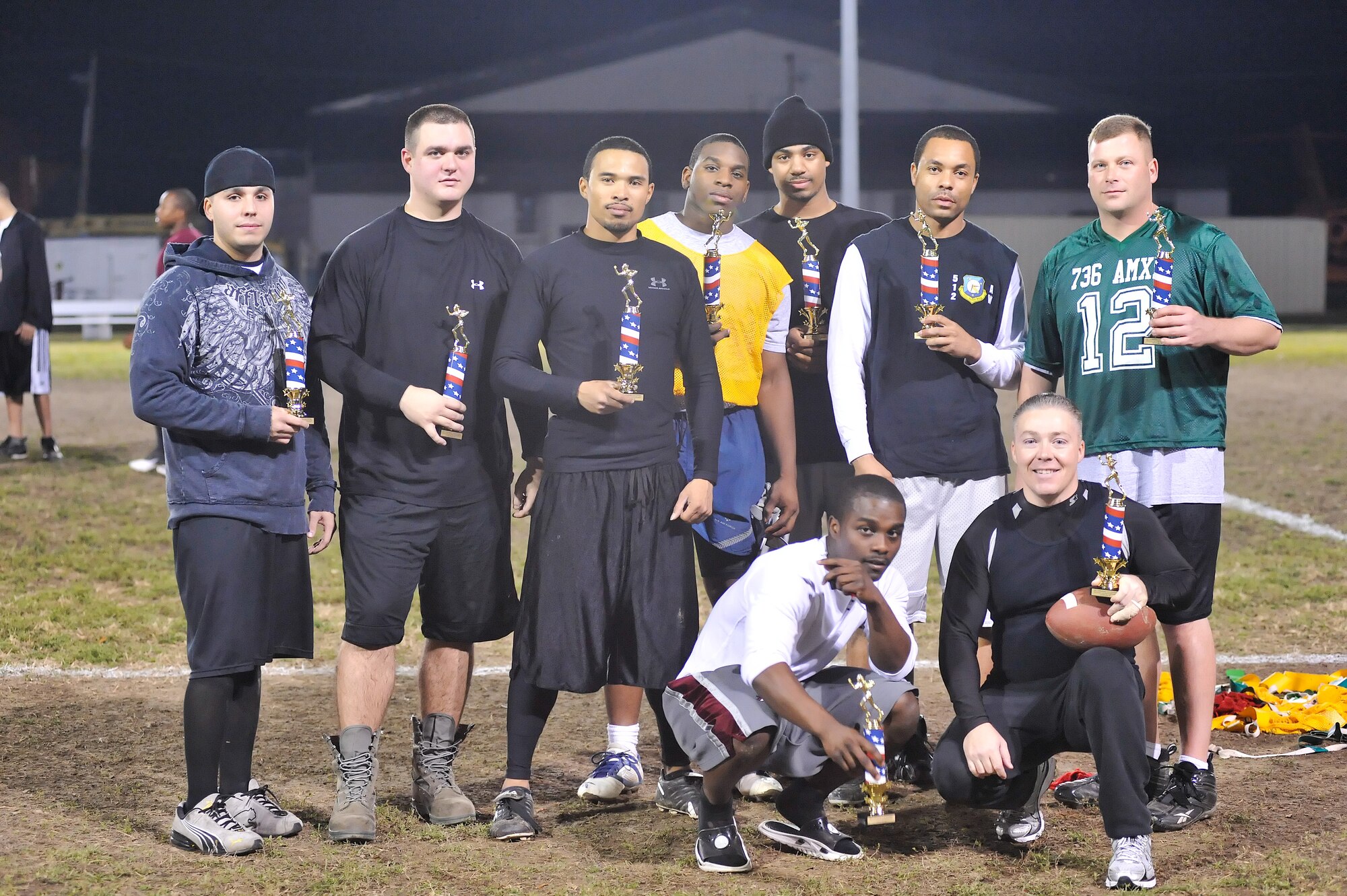 Members of the National League flag football pose with their trophies Nov. 22, 2010, after their loss to the American League 19 – 13. (U.S. Air Force photo by Airman 1st Class Matthew Hubby/Released)