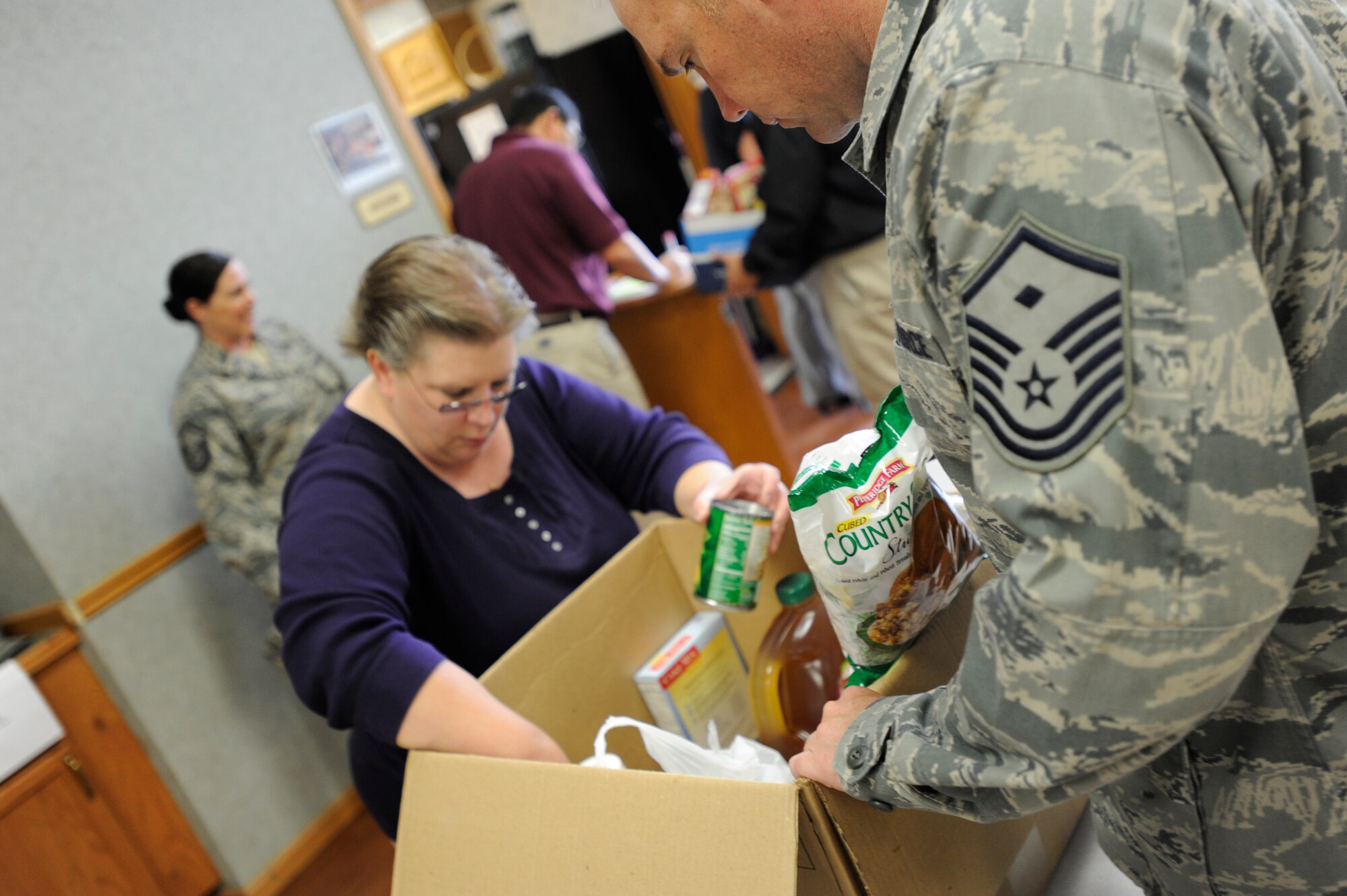 Alisa A. Norlin, 22nd Force Support Squadron family advocacy outreach manager, builds a Thanksgiving basket of food items, Nov. 11, 2010, McConnell Air Force Base. Kan. The baskets were full of items donated by McConnell members to help out other Airmen and their families to have a traditional Thanksgiving dinner. The event was led by the Airman and Family Readiness Center. (U.S. Air Force photo/Airman 1st Class Armando A. Schwier-Morales) 