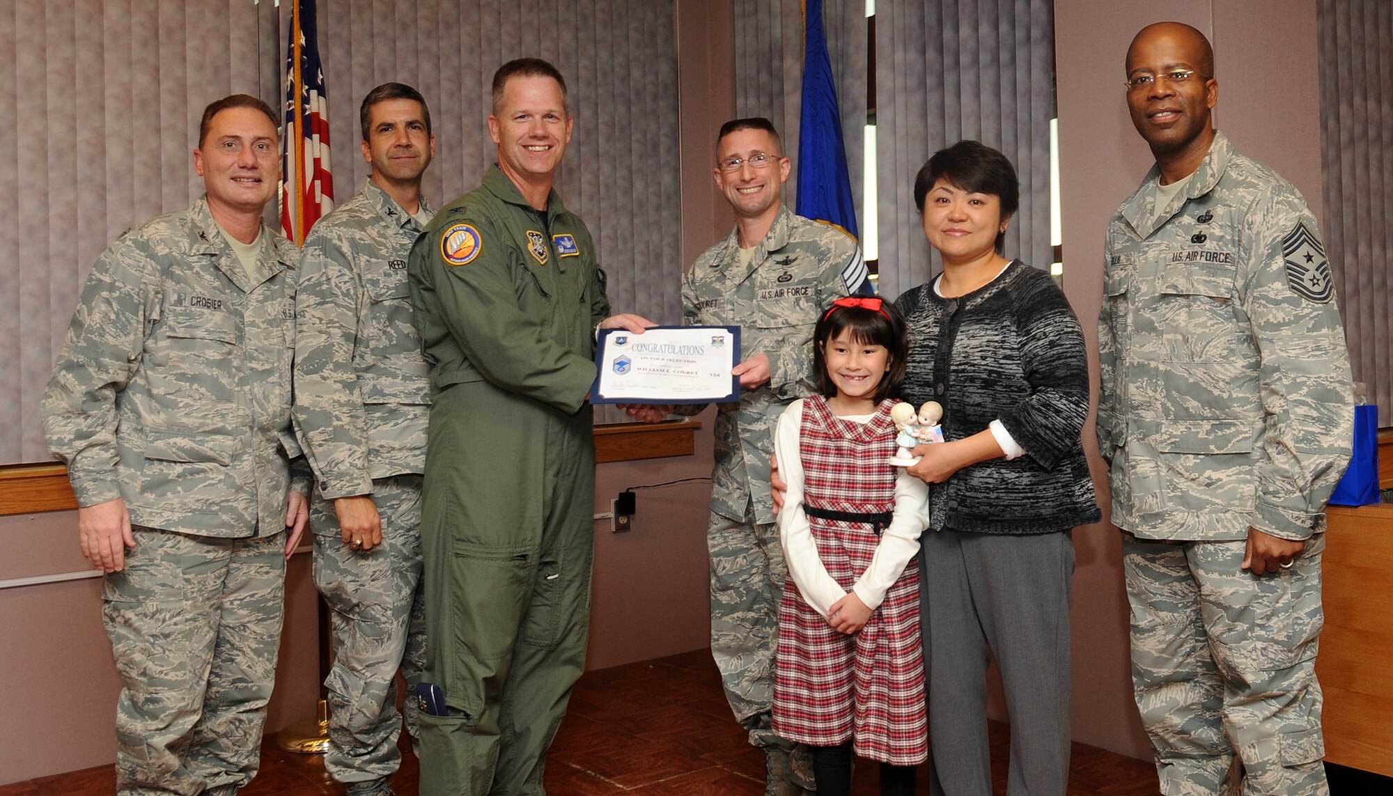 Buckley Air Force Base, Colo.-  Chief Master Sgt. (Select) William Couret is congratulated by Col. Clinton Crosier and Chief Master Sgt. Robert Ellis during the Chief Promotion party held at Newtch's Den.  ( U.S. Air Force Photo by Airman 1st Class Marcy Glass )

