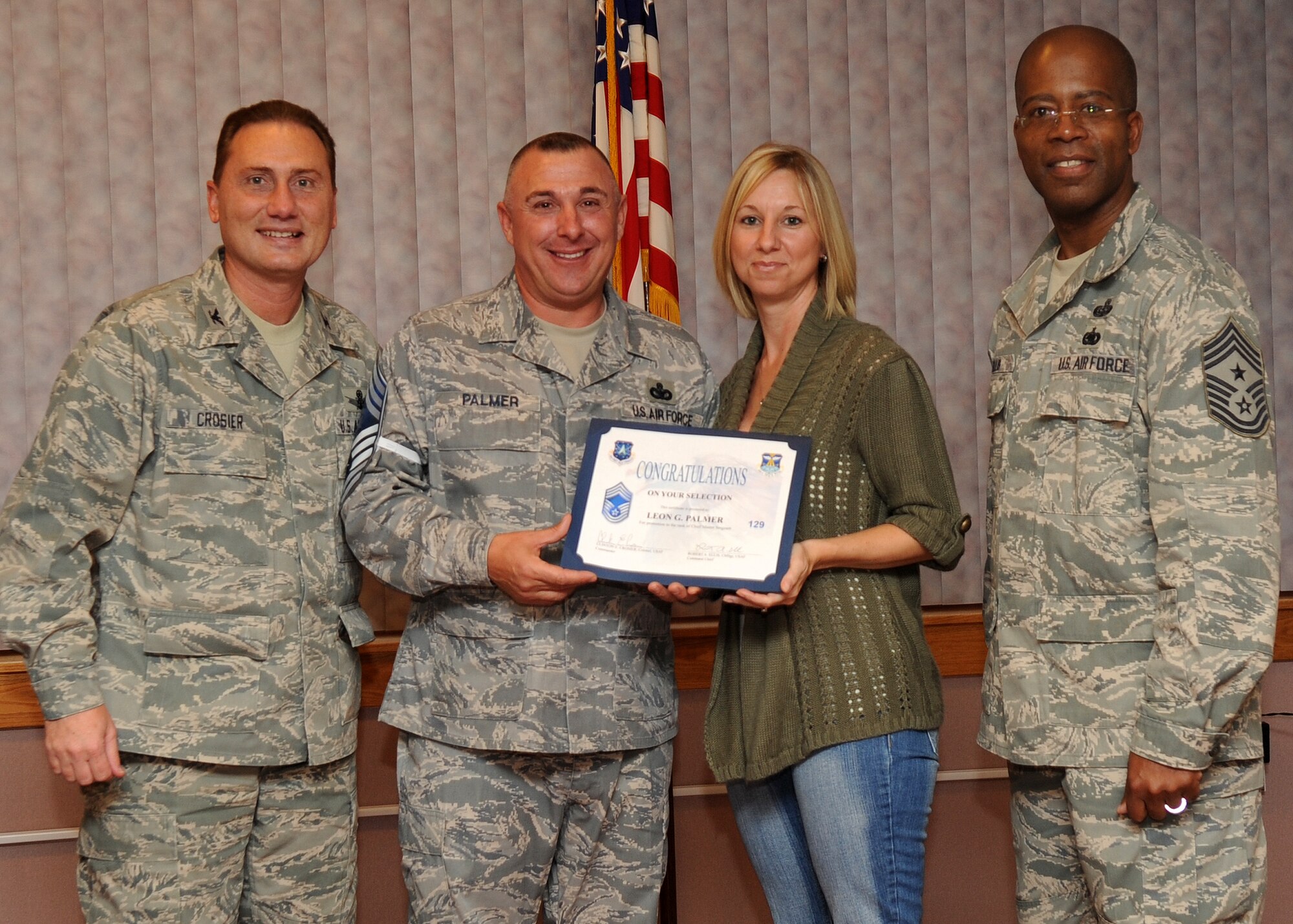 Buckley Air Force Base, Colo.-  Chief Master Sgt. (Select) Leon Palmer is congratulated by Col. Clinton Crosier and Chief Master Sgt. Robert Ellis during the Chief Promotion party held at Newtch's Den.  ( U.S. Air Force Photo by Airman 1st Class Marcy Glass )