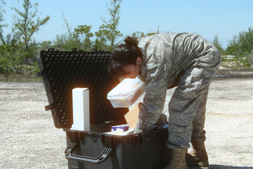 WRIGHT-PATTERSON AIR FORCE BASE, Ohio - Maj. Anna Kaus, a registered nurse assigned to the 445th Aerospace Medicine Squadron, retrieves medical treatment supplies during land evasion continuation training in Key West, Fla. Major Kaus along with other 445th AMDS personnel accompanied 445th Airlift Wing reservists attending water survival and land evasion training to provide medical support during the Oct. 14-15 training held at the Naval Air Station. (U.S. Air Force photo/Capt. Rodney McNany)