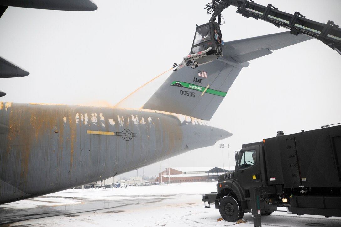 Tech. Sgt. Mark Heius, in truck, operates a deicing truck as Airman 1st Class A. Garcia deices a C-17 Globemaster III before a mission Nov. 22, 2010, during the first snowfall of the season at Joint Base Lewis-McChord, Wash. Both Airmen are assigned to the 62nd Aircraft Maintenance Squadron. (U.S. Air Force photo/Tech. Sgt. Oshawn Jefferson)