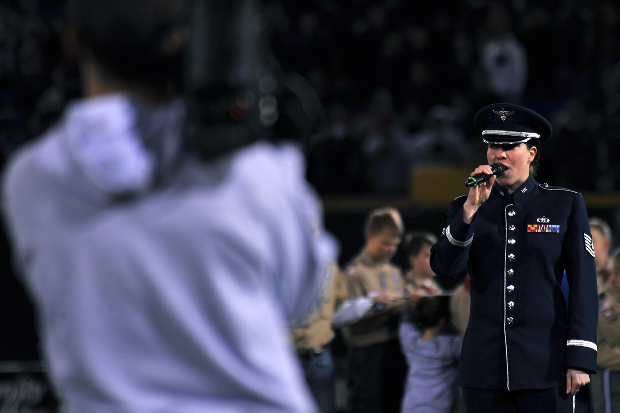 OFFUTT AIR FORCE BASE, Neb. - Technical Sgt. Victoria Bruyette, a vocalist with Air Combat Command's Heartland of America Band, sings the national anthem during the Omaha Nighthawks military appreciation game at the Rosenblatt Nov. 19. Military members from all branches were celebrated at the game, which ended with a Florida Tuskers win 27 to 10. U.S. Air Force Photo by Charles Haymond (Released)