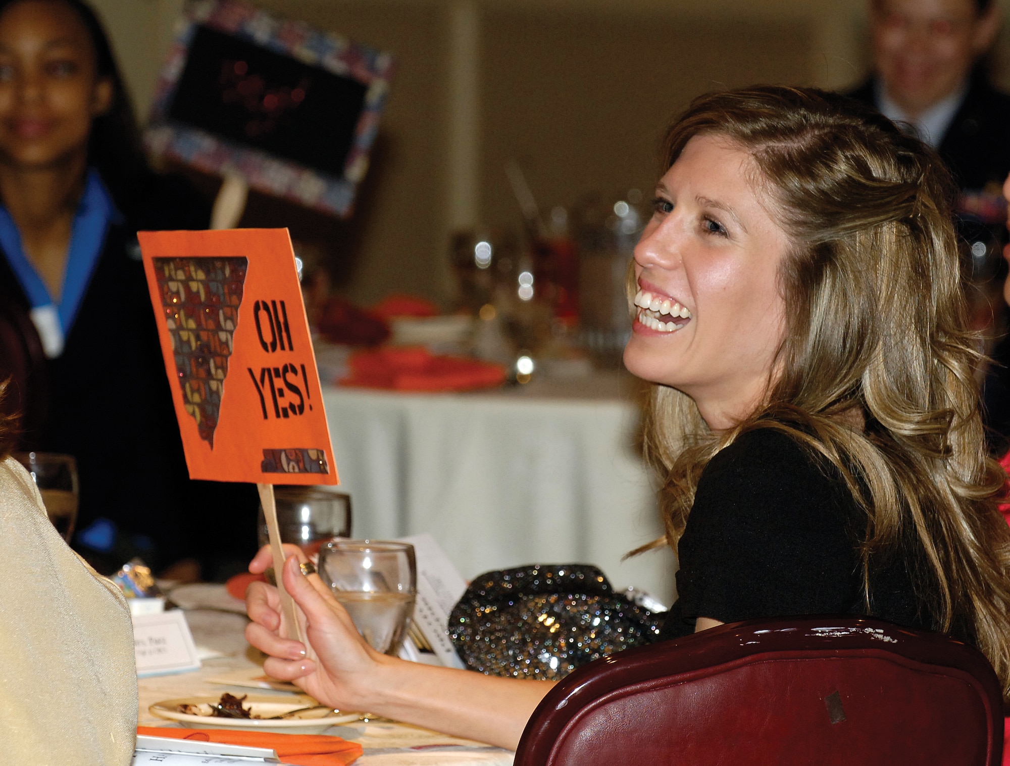 With a definite “yes” vote, Kaci Smith offers her opinion on what is and isn’t appropriate dress at a military function. Ms. Smith, wife of Airman Ronny Smith with the 552nd Aircraft Maintenance Squadron, was one of 60 enlisted spouses who attended the Tinker Enlisted Spouses Network Protocol Dinner Nov. 16 at the Tinker Club. (Air Force photo by Margo Wright)