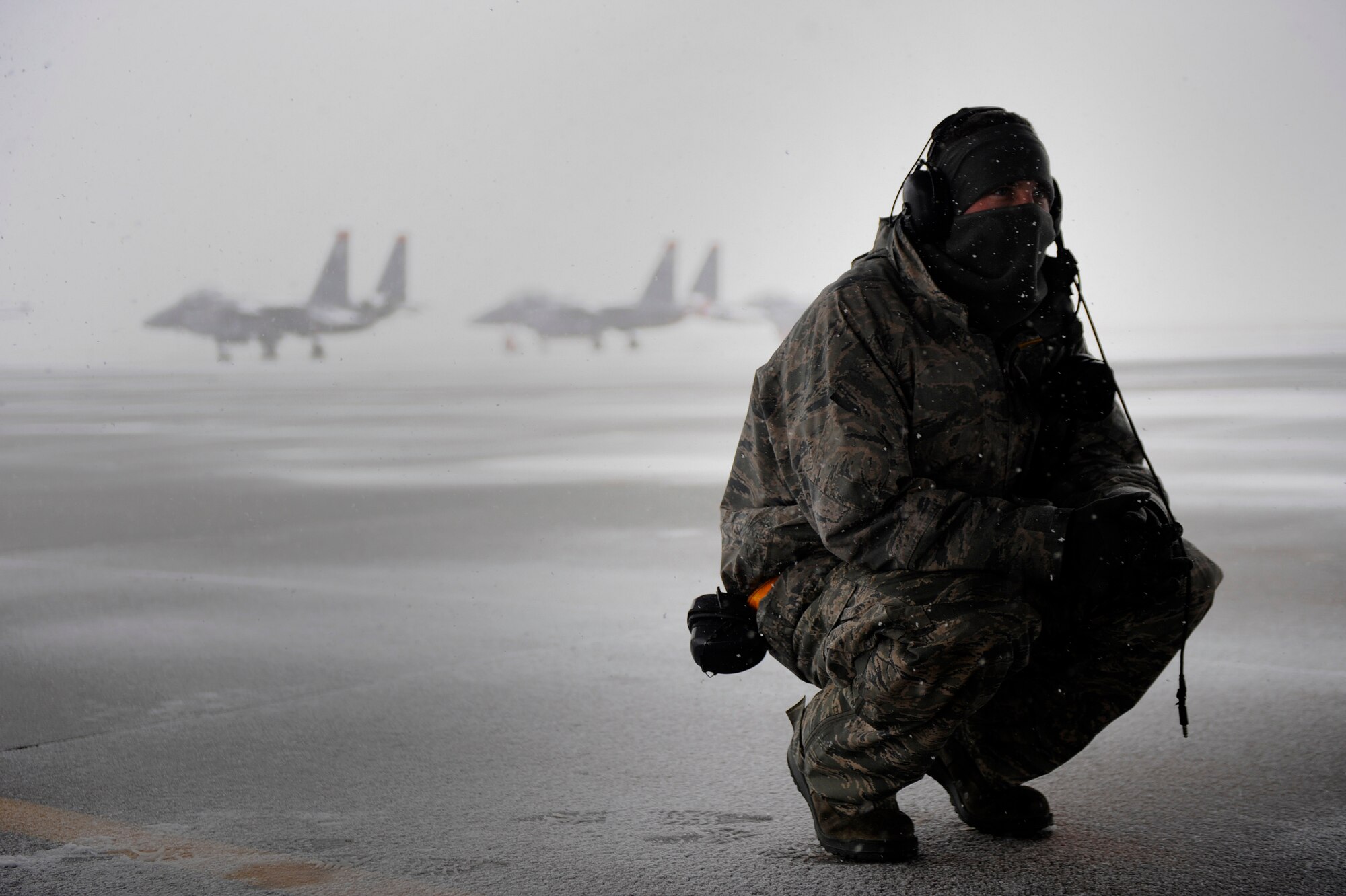 MOUNTAIN HOME AIR FORCE BASE, Idaho -- Senior Airman Stephen Held, 391st Aircraft Maintenance Unit crew chief, takes a break under an aircraft to hide from the snow during an operational readiness exercise here Nov. 21. The wing uses OREs to gauge its ability to meet wartime taskings at a deployed location. The evaluation includes initial response, readiness, combat operations, ability to survive and operate, self aid and buddy care and mission support. (U.S. Air Force photo by Senior Airman Renishia Richardson)