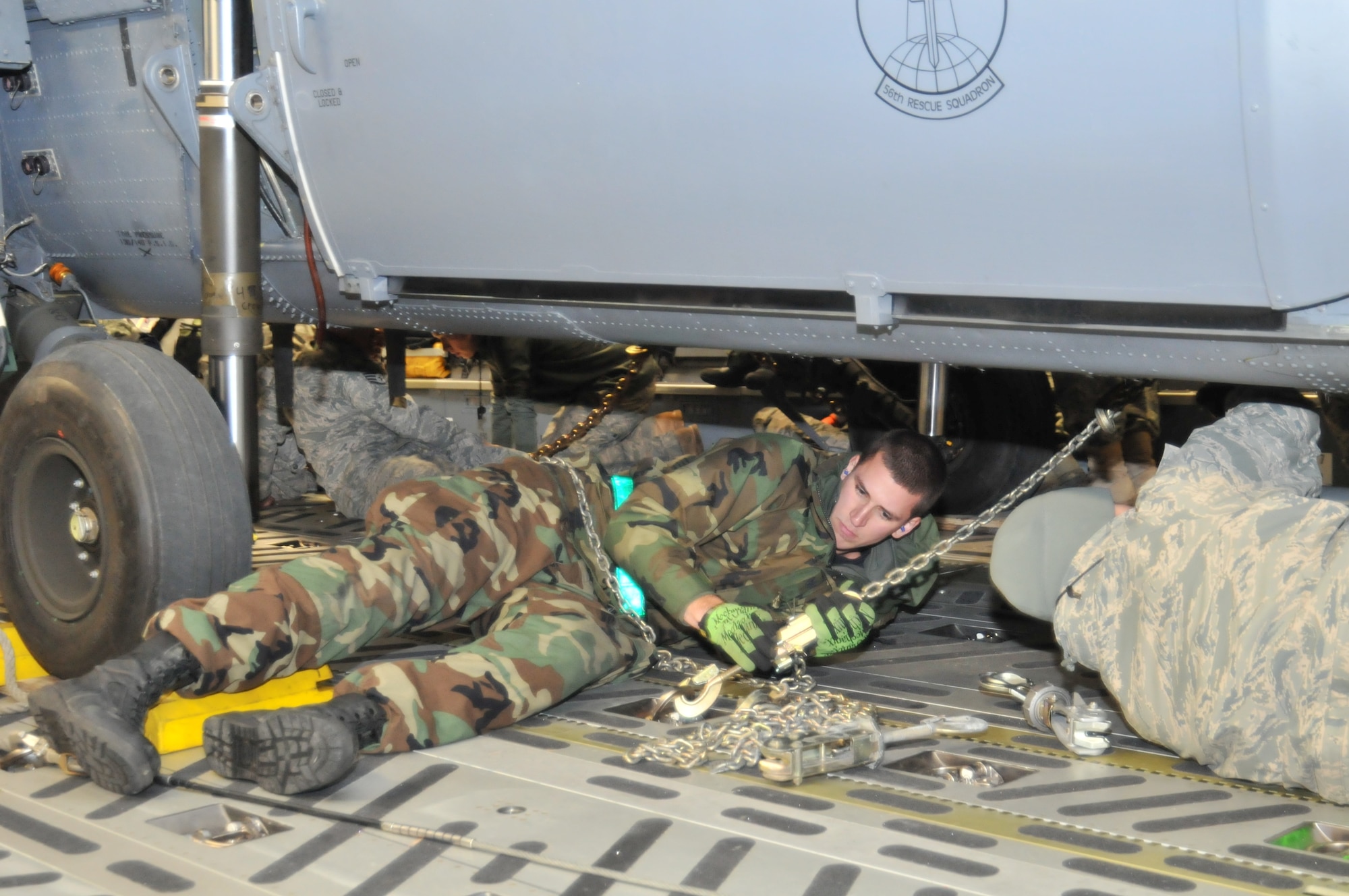 ROYAL AIR FORCE LAKENHEATH, England – Staff Sgt. Benjamin Halaszynski, 748th Aircraft Maintenance Squadron communication/navigation mission systems technician, secures an HH-60G Pave Hawk helicopter to the cargo floor of a C-17 Globemaster III on Nov. 22. Two helicopters were loaded on the C-17, each requiring anchoring at 18 points before the aircraft could take off. (U.S. Air Force photo/Senior Airman David Dobrydney)