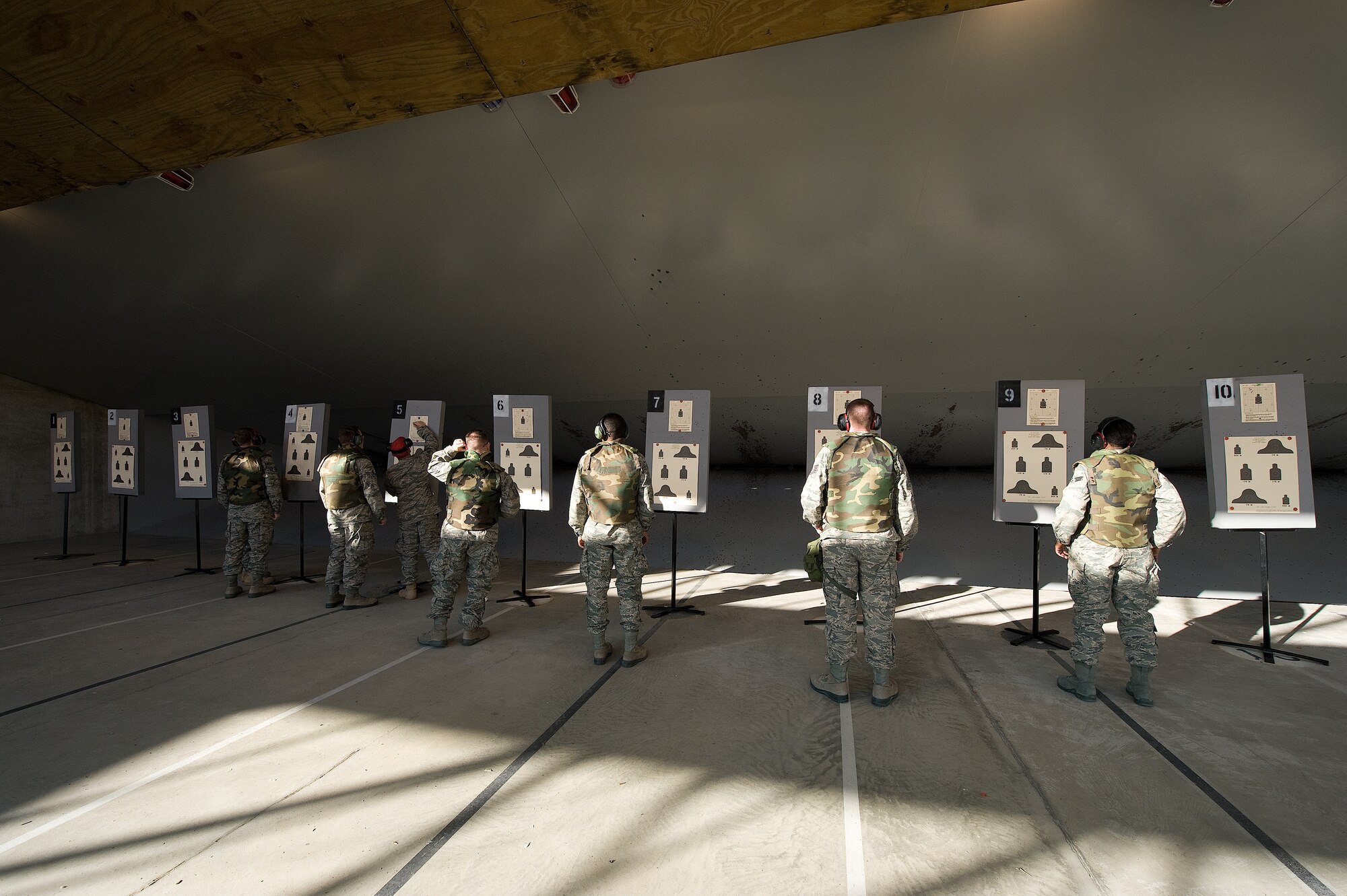 Tops in Blue members take a look at their sighting targets Nov. 22, 2010 during a weapons qualification at the Dover Air Force Base, Del., combat arms firing range. They sighted their weapons with the practice targets to ensure that they would be able to sight the weapon properly. (U.S. Air Force photo by Jason Minto/Released)