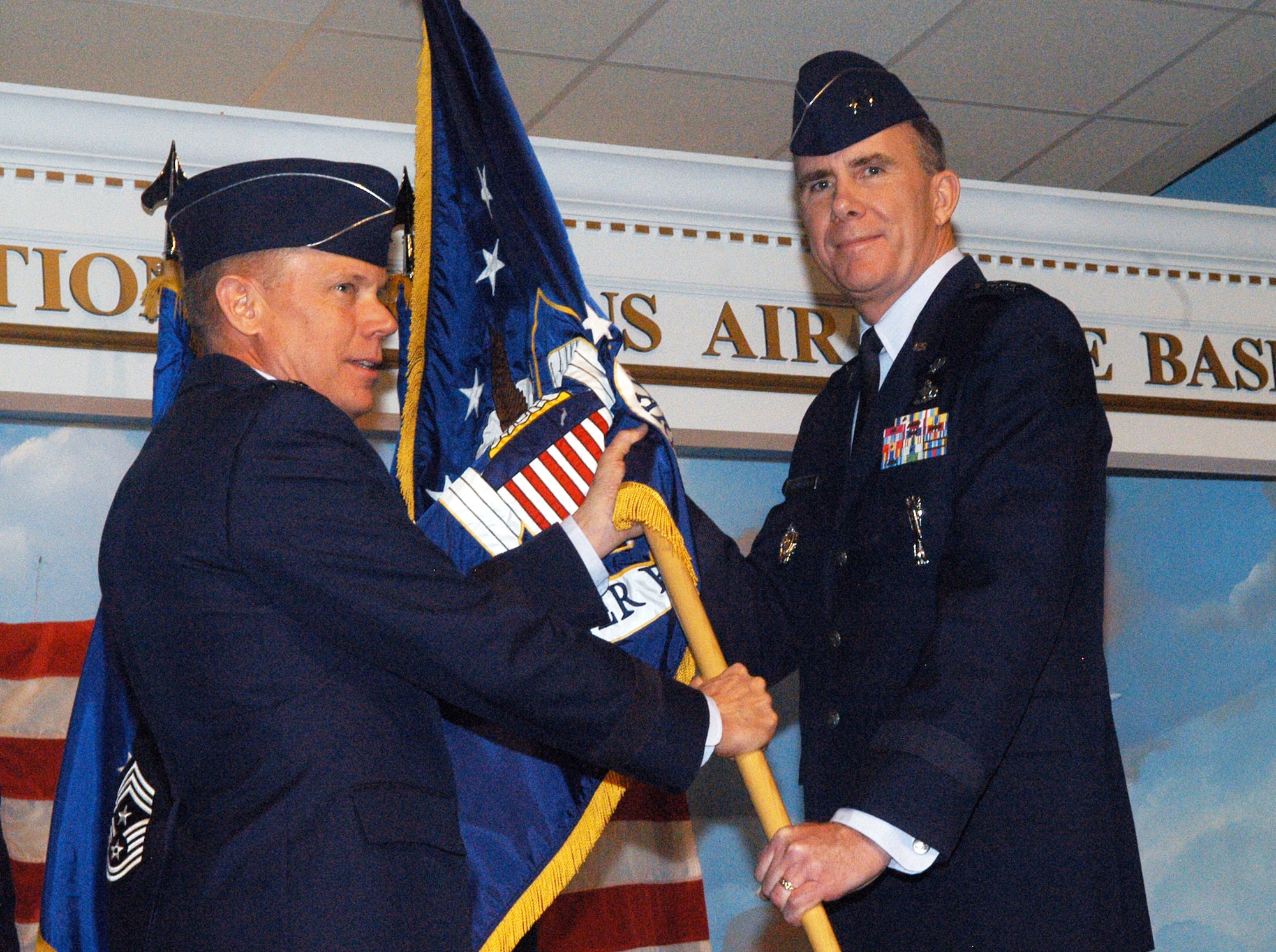 Gen. Donald Hoffman, commander of Air Force Materiel Command, passes the guidon to  Maj. Gen. Robert H. McMahon as he assumes command of Warner Robins Air Logistics Center Nov. 19. U. S. Air Force photo by Sue Sapp
