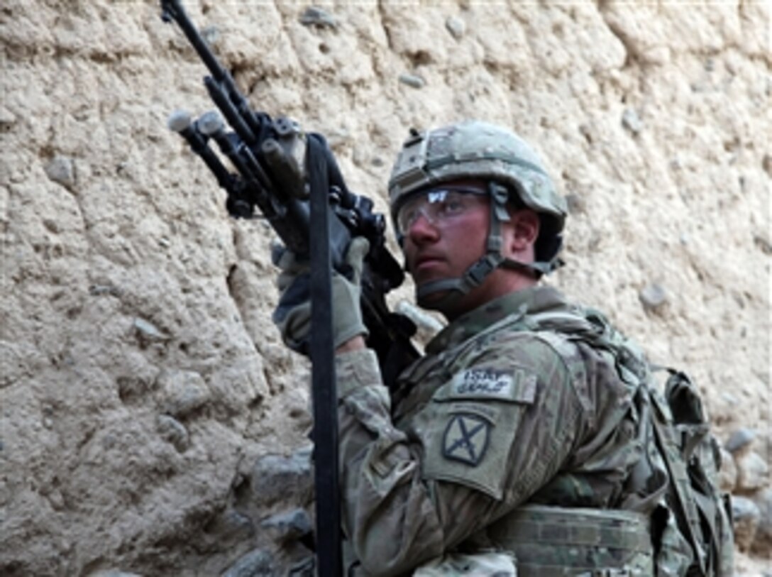 U.S. Army Pvt. Michael Cozad, with 2nd Platoon, Charlie Troop, 3rd Squadron, 89th Cavalry Regiment, 4th Brigade Combat Team, 10th Mountain Division, watches the rooftops for enemy snipers in Charkh district, Logar province, Afghanistan, on Nov. 13, 2010.  