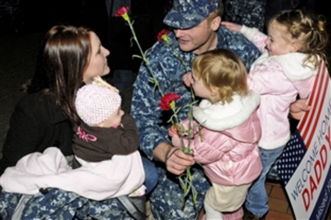 U.S. Navy Petty Officer 2nd Class Kyle Peterson reunites with his wife and his daughters after returning from a three-month deployment in Bangor, Wash., Nov. 20, 2010. Peterson, a machinist's mate is assigned to the guided-missile submarine USS Michigan.