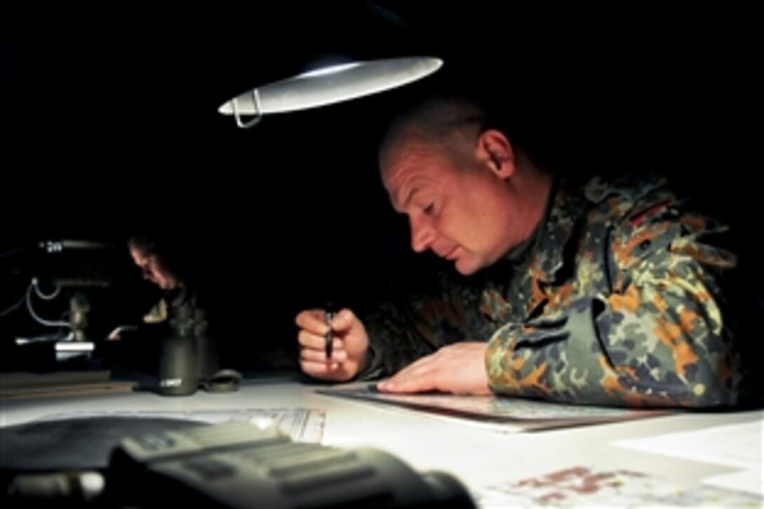 A German soldier charts map coordinates while participating in a NATO mentor and liaison team  training exercise at the Joint Multinational Readiness Center in Hohenfels, Germany, Nov. 10,  2010.