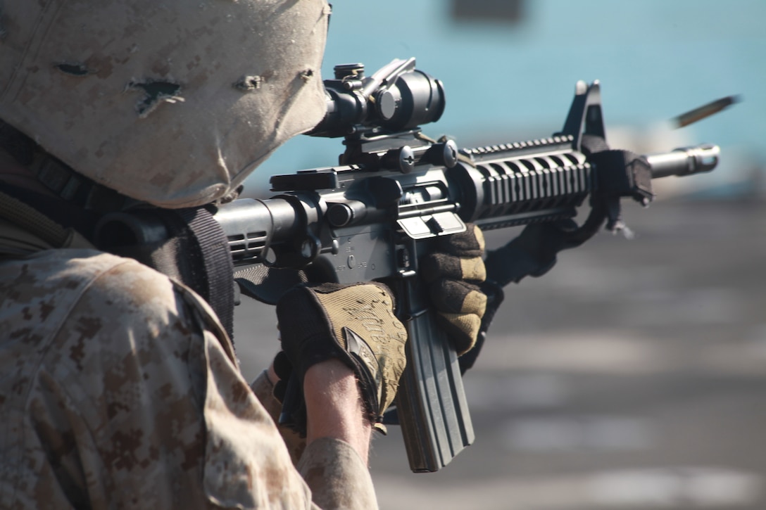 A Marine with Company L, Battalion Landing Team 3/8, 26th Marine Expeditionary Unit, engages a target during a Combat Marksmanship live-fire exercise on the flight deck aboard USS Carter Hall, Nov. 24, 2010. 26th MEU is deployed aboard the ships of the Kearsarge Amphibious Ready Group in the 5th Fleet area of responsibility and serving as the theater reserve force. (Official USMC photo by Sgt. Jesse J. Johnson/ Released)::r::::n::