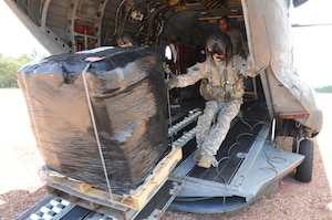 FUERZA MOROCON, Honduras --  Cpl. Brian Godfreaux, left, and Staff Sgt. Jeremy Dudley, both crew chiefs with the 1-228th Aviation Regiment, unload one pallet of rechargeable batteries from a CH-47 Chinook helicopter here Nov. 23. The 1-228th delivered 44 rechargeable batteries to this remote base to ensure the Honduran Infantry Battalion has power during the night. (U.S. Air Force photo/Tech. Sgt. Benjamin Rojek)