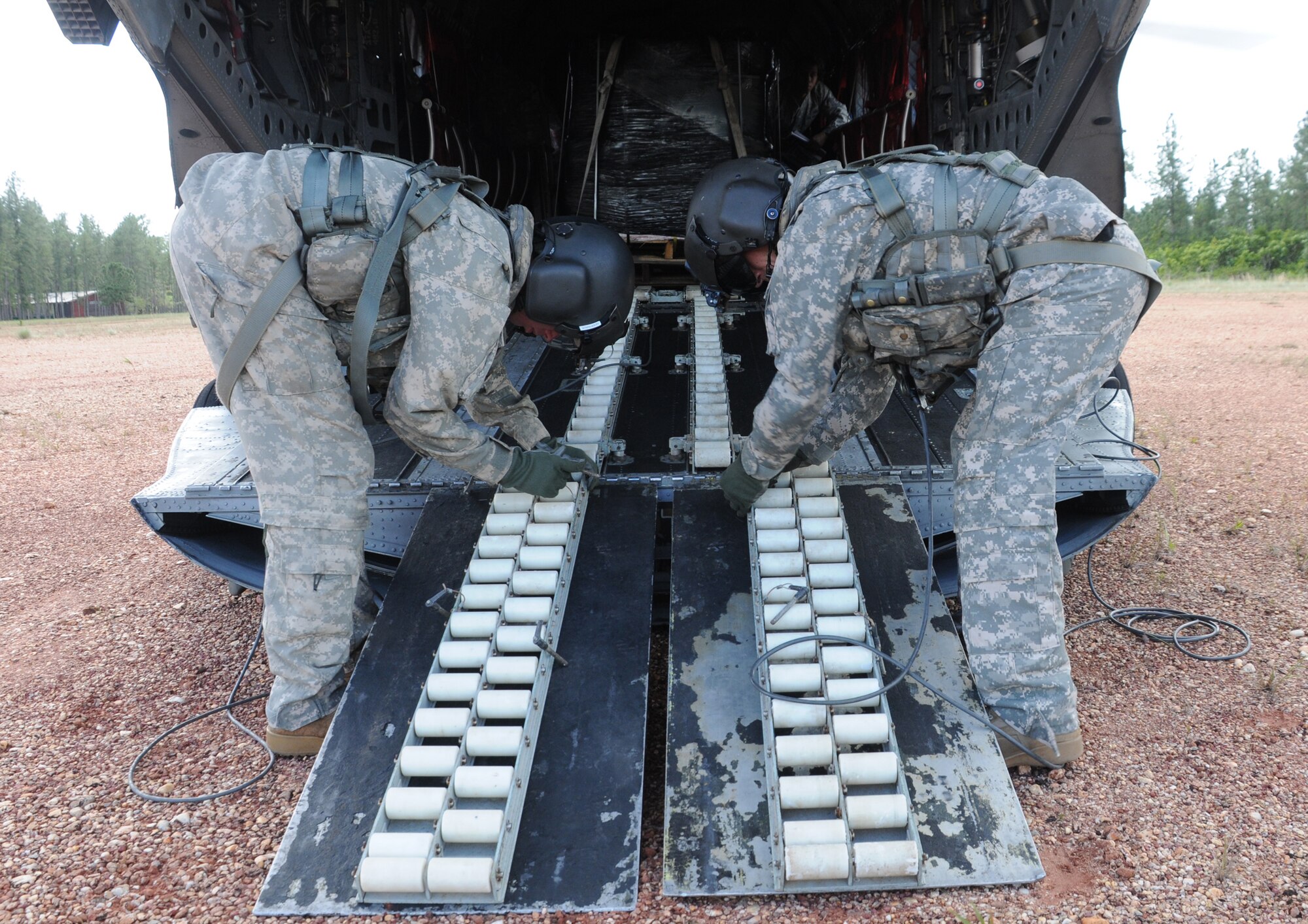 FUERZA MOROCON, Honduras --  Cpl. Brian Godfreaux, left, and Staff Sgt. Jeremy Dudley, both crew chiefs with the 1-228th Aviation Regiment, prepare the ramp of a CH-47 Chinook helicopter here Nov. 23. The 1-228th flew 44 rechargeable batteries to this remote base to ensure the Honduran Infantry Battalion has power during the night. (U.S. Air Force photo/Tech. Sgt. Benjamin Rojek)