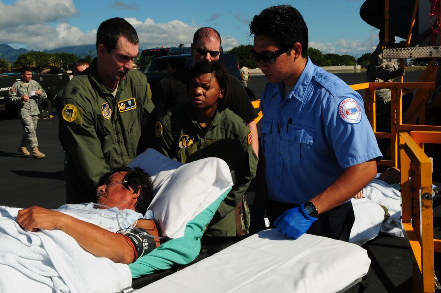 Lt. Col. (Dr.) Peter Crawley (left), chief, Critical Care Air Transport Team East element, Captain Tina Hall, a flight nurse with CCATT East element, and a Hawaii American Medical Response technician, transport a critically ill patient from a KC-135 to Tripler Army Medical Center, Hawaii, on Nov. 23, 2010.  The CCATT is a specialized, three-person medical team whose primary mission is to provide critical care management for critically ill or injured patients who require transport to advanced medical treatment facilities. (U.S. Air Force photo / Tech. Sgt. Kerry Jackson)