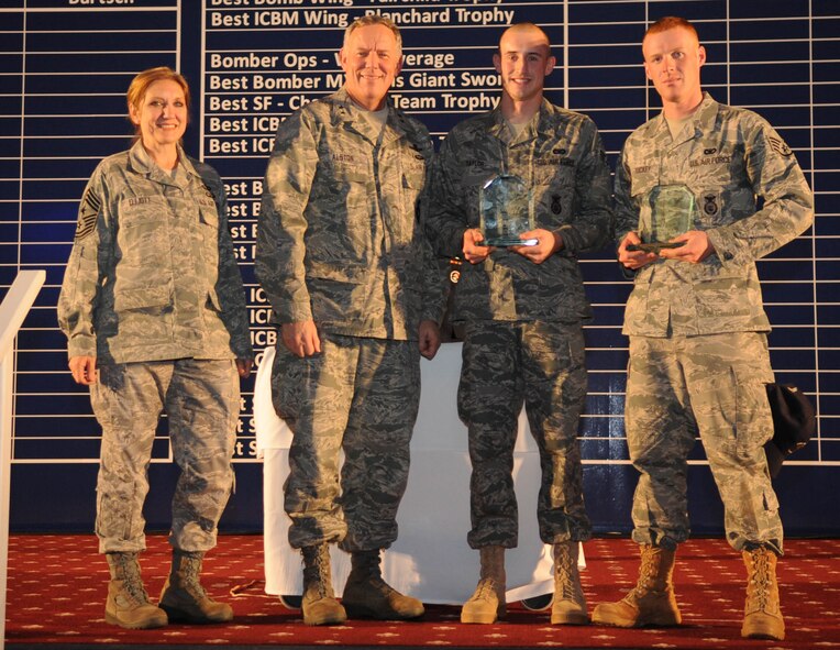 Chief Master Sgt. Tammy Elliot and Maj. Gen. C. Donald Alston post with Senior Airman Dustin Taylor and Staff Sgt. Jeffrey Tuckey after they were named the best M240B Machine Gun Team at the Global Strike Challenge score posting. (U.S. Air Force photo/Senior Airman Alexandra Boutte)