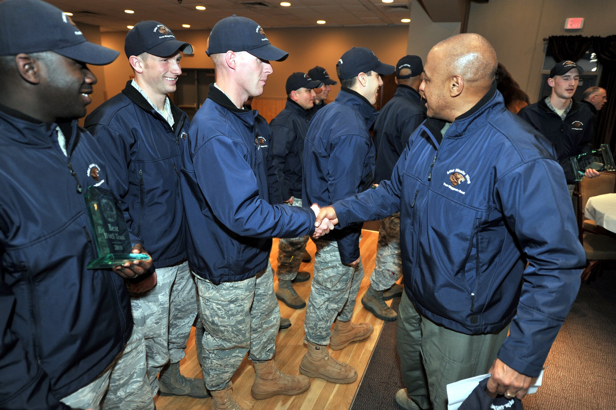 The 341st Missile Wing Commander Col. Anthony Cotton shakes hands with 341st Security Forces Group Global Strike Challenge team members Staff Sgt. Jeffrey Tuckey, during the welcome home celebration at the Grizzly Bend Club Nov. 18. Sergeant Tuckey claimed two trophies during the compeition -- as a member of the best Securty Forces Endurance team as as a member of the best M240B machine gun team. (U.S. Air Force photo/John Turner)