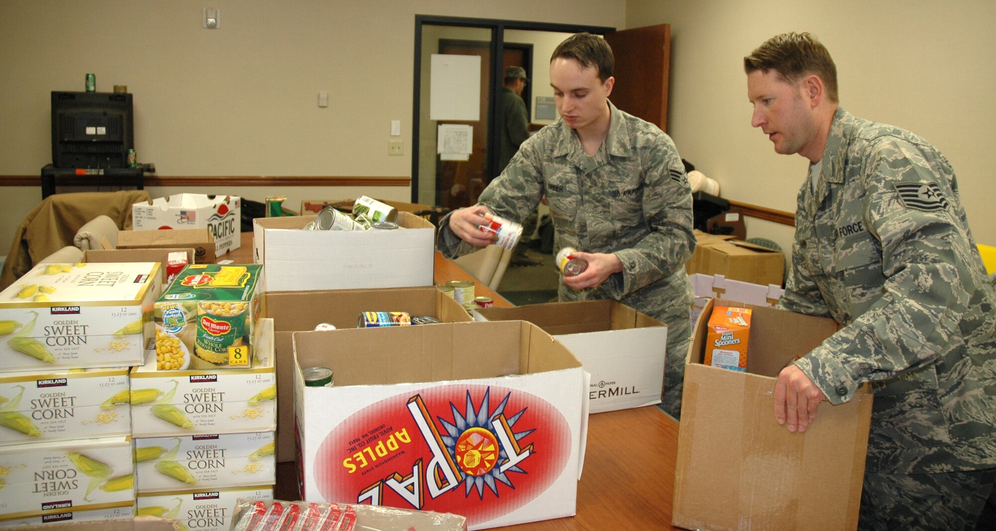 JOINT BASE LEWIS-MCCHORD, Wash.- Senior Airman Nicolas Speer, 446th Logistics Readiness Flight and Tech. Sgt. Nathan Mann, 446th Aircraft Maintenance Squadron, prepare Thanksgiving baskets with food donated from the USO in the 446th Mission Support Group Airmen and Family Readiness Center, Nov. 23. The baskets will be to be distributed to needy families from the 446th Airlift Wing. The Care and Share Program is designed to help wing families in need during the holiday season. Reservists with Airmen and Family Readiness, 446th LRF, and 446th AMXS helped put together about 30 baskets of food to distribute to families. About 20 gift cards will be sent out to families who live more than 50 miles away from base and didn't receive a basket. (U.S. Air Force photo/Master Sgt. Jake Chappelle)