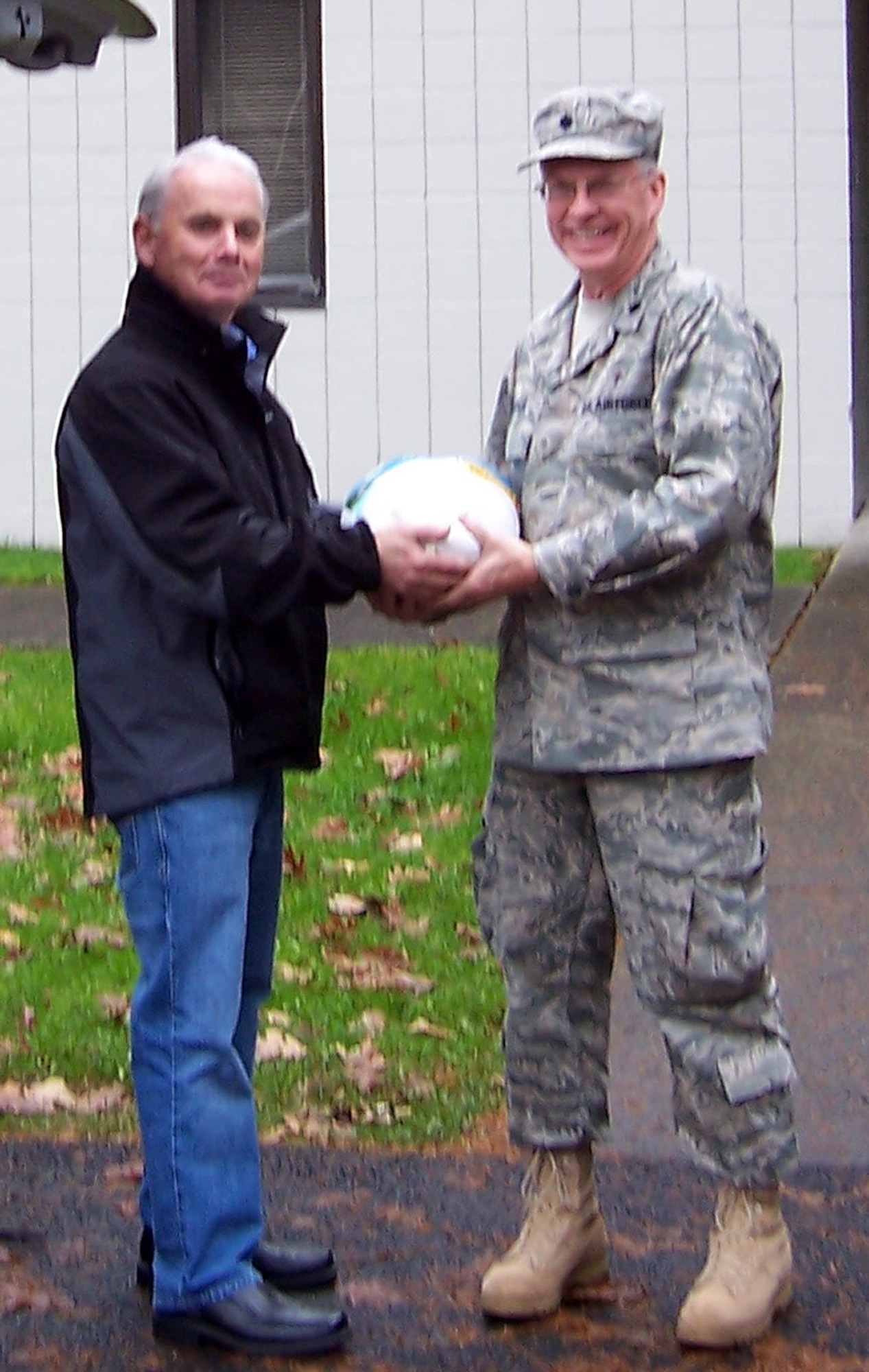 JOINT BASE LEWIS-MCCHORD, Wash.- 446th Airlift Wing Chaplain (Lt. Col.) Carl Supplee accepts a Thanksgiving turkey from Dennis Daily, general manager Auto Warehousing Company in Port of Tacoma, Wash., Nov. 19. The turkey represents the 30 turkeys that were donated to the 446th Mission Support Group Airmen and Family Readiness Center for the Wing Care and Share Program. The turkeys will be added to the Thanksgiving baskets with food donated from the USO to give to wing families in need during the holidays. Chaplain Supplee is also the Airmen and Family Readiness Center Director. (Courtesty photo)