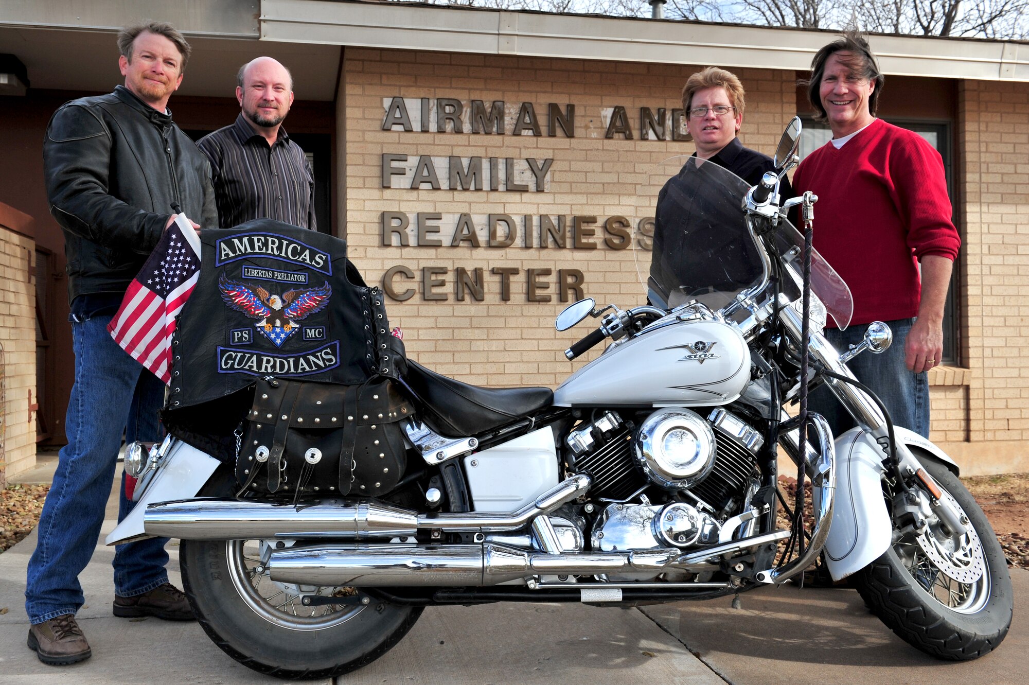 (from left to right) Michael King, 27th Special Operations Group and member of Americas Guardians motorcycle club; Charles Harris, John Fondrick, and Thomas Hittle, 27th Special Operations Force Support Squadron, assemble to mark the donation of $1,635.18 at Cannon Air Force Base, Nov 24, 2010. The donation goes to Friends of Family Support and in turn into a local wounded warrior fund. The local chapter of Americas Guardians in Clovis and Portales consists of veterans and first responders. (U.S. Air Force photo by Tech Sgt. Josef Cole)(RELEASED)