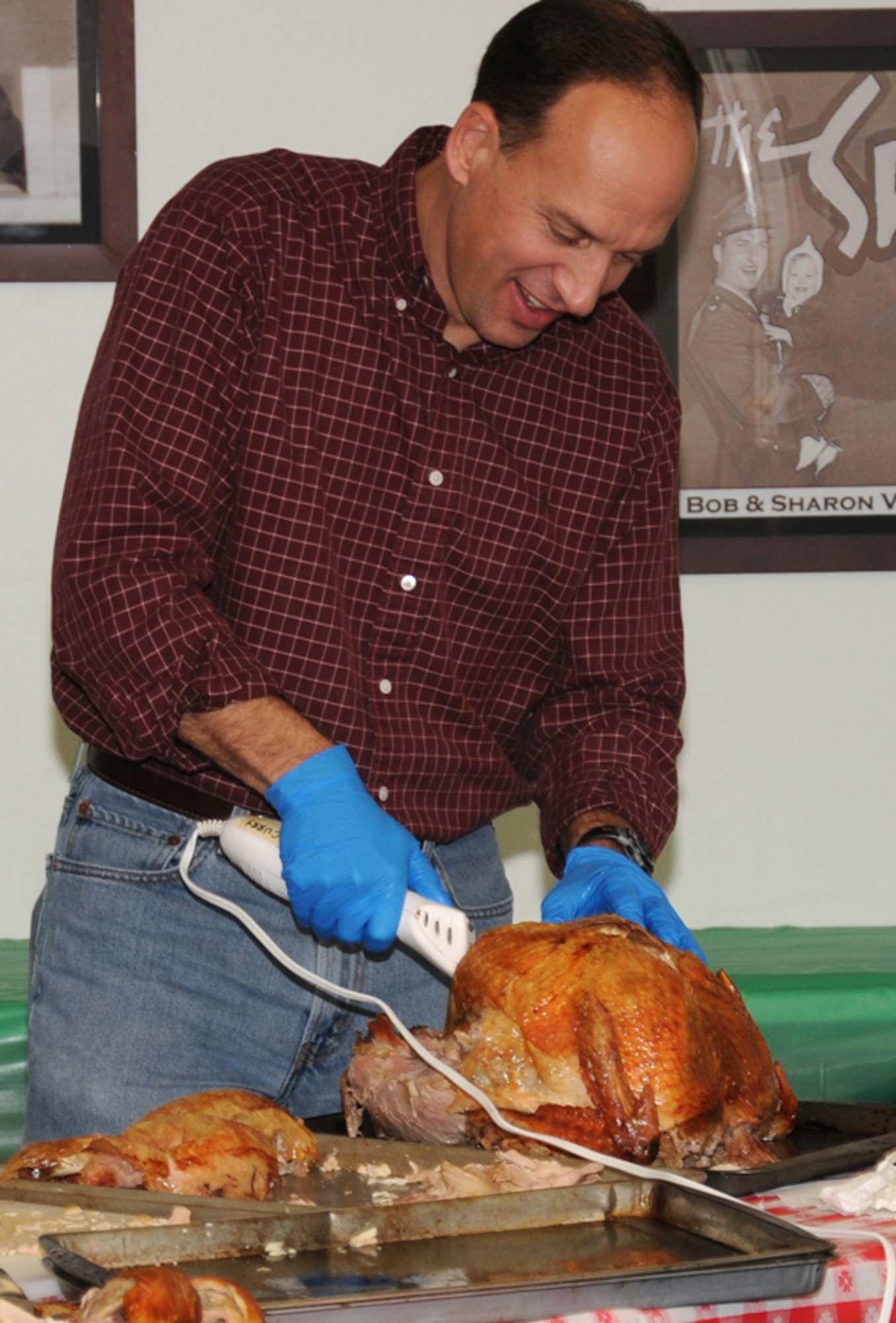 Col. Douglas Curry, the 71st Medical Group commander, carves one of 10 turkeys served at the Thanksgiving Singles’ International Gourmet Meal Opportunity, Nov. 22, at the Vance Community Chapel Activity Center. Two hundred single Airmen and family members of deployed Airmen were served a traditional meal with all the fixings. (U.S. Air Force photo/ Angie Roche)