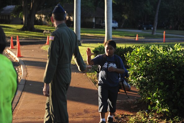 Col. Joe Dague, 15th Wing vice commander, greets a student of Hickam Elementary as head to school Nov. 24 at Joint Base Pearl Harbor Hickam. 15th Wing leadership visited the school to wish students and parents a happy and safe Thanksgiving. (U.S. Air Force photo/Staff Sgt. Nathan Allen) 

