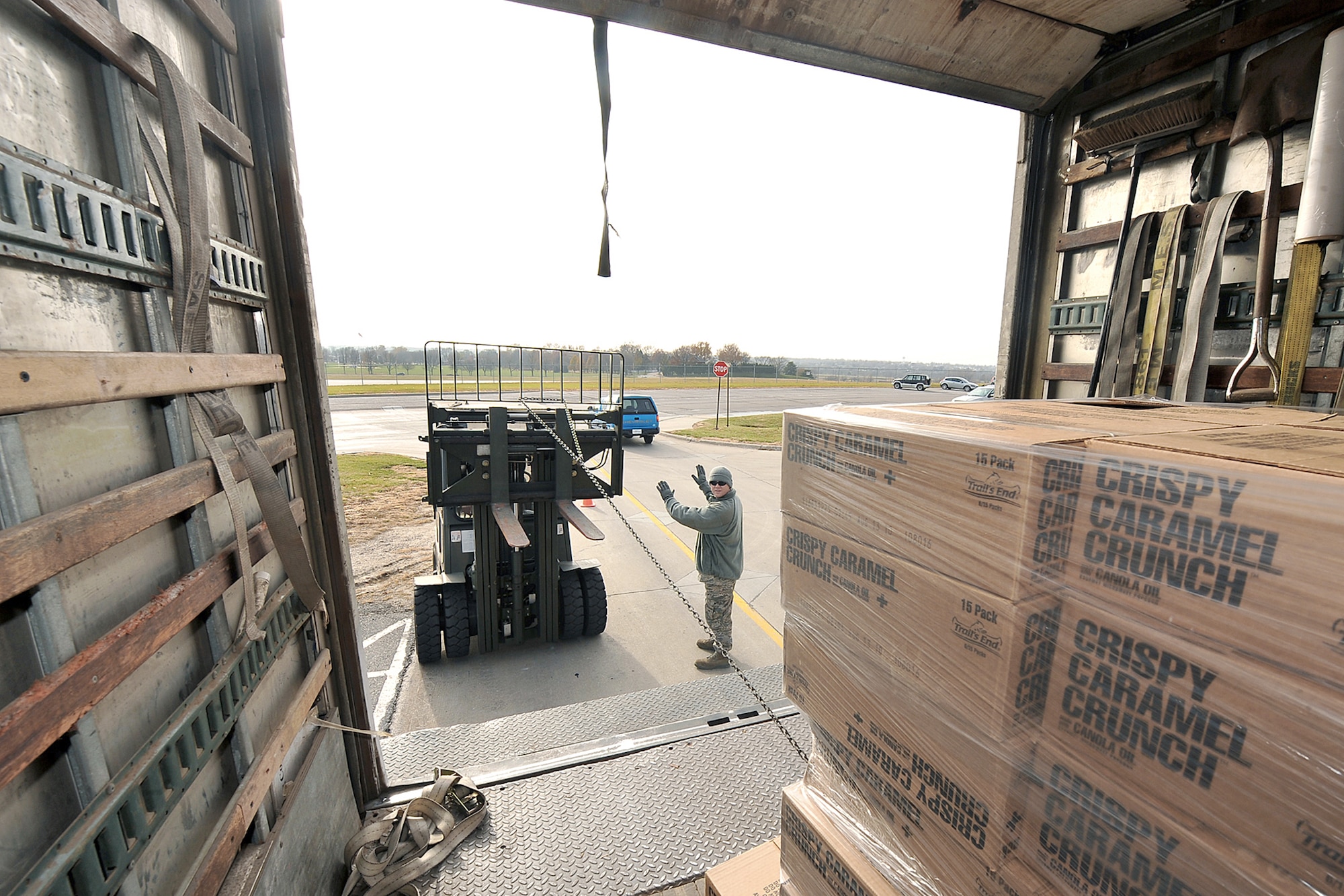 Tech. Sgt. Timothy Lawrence moves pallets of popcorn with a forklift while Staff Sgt. Waylon Owens directs him Nov. 18, 2010, at Offutt Air Force Base, Neb. Both are assigned to the 55th Force Support Squadron. (U.S. Air Force Photo by Charles Haymond)