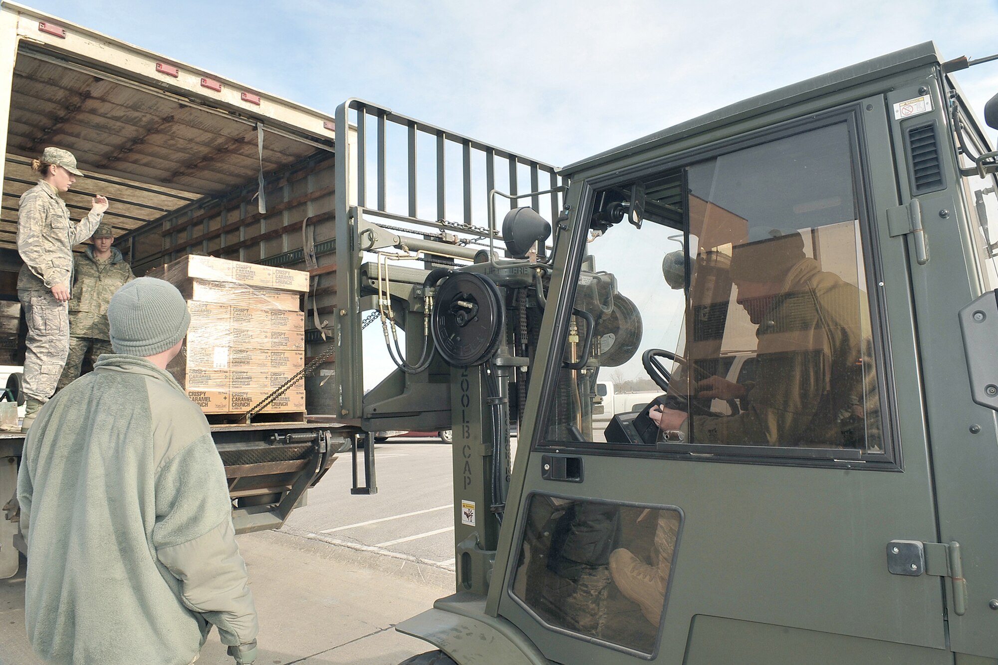 First Lt. Robyn Thome helps direct Tech. Sgt. Timothy Lawrence as he moves a pallet of popcorn Nov. 18, 2010, at Offutt Air Force Base, Neb. Lieutenant Thome is assigned to the 55th Wing Protocol Office, and Sergeant Lawrence is assigned to the 55th Force Support Squadron. (U.S. Air Force Photo by Charles Haymond)