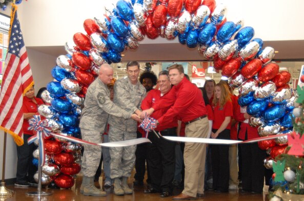 Left to right, Chief Master Sgt. Bill Thomaston, 95th Air Base Wing command chief; Col. Gregory E. Schwab, 95th Air Base Wing commander; Mr. Russ Hinrichs, Army-Air Force Exchange Service Base Exchange manager and Mr. Jeff Wigness, AAFES West Coast area Western Regional manager, perform the ribbon cutting duties at the grand re-opening of the exchange facilities Nov. 19, while some of the 166 exchange associates look on. (Air Force photograph by Stephen K. Robinson)