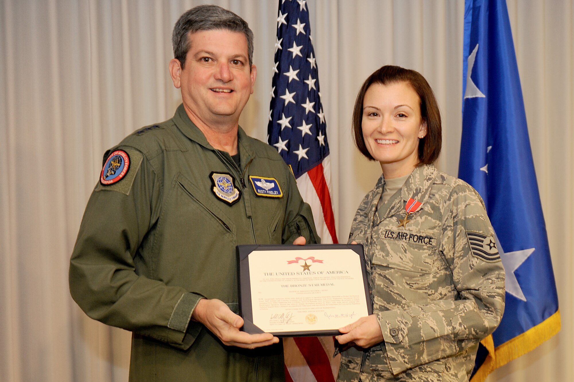 SCOTT AIR FORCE BASE, Ill. -- Lt. Gen. Rusty Findley, Air Mobility Command vice commander, presents a Bronze Star to Tech. Sgt. Heather Henry, NCOIC of AMC’s Commander’s Action Group, for her actions on a recent six-month deployment to Afghanistan. (U.S. Air Force Photo by Staff Sgt. Brian Valencia)

