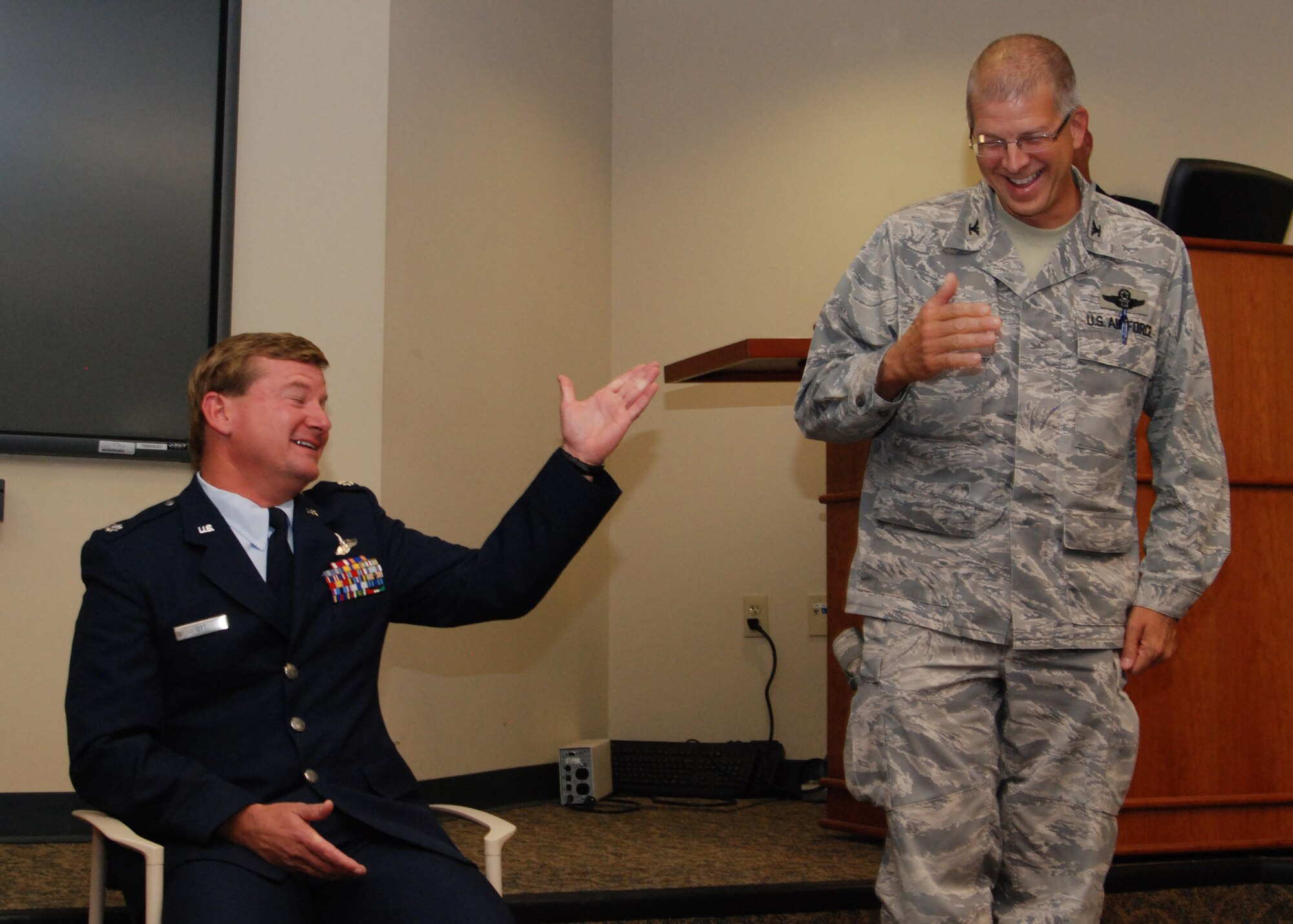 During his retirement ceremony, Lt. Col. Mark Ott, 700th Airlift Squadron evaluator and pilot, shares a humorous moment with Col. Timothy Tarchick, 94th Airlift Wing commander. (U.S. Air Force photo/Master Sgt. Stan Coleman)  