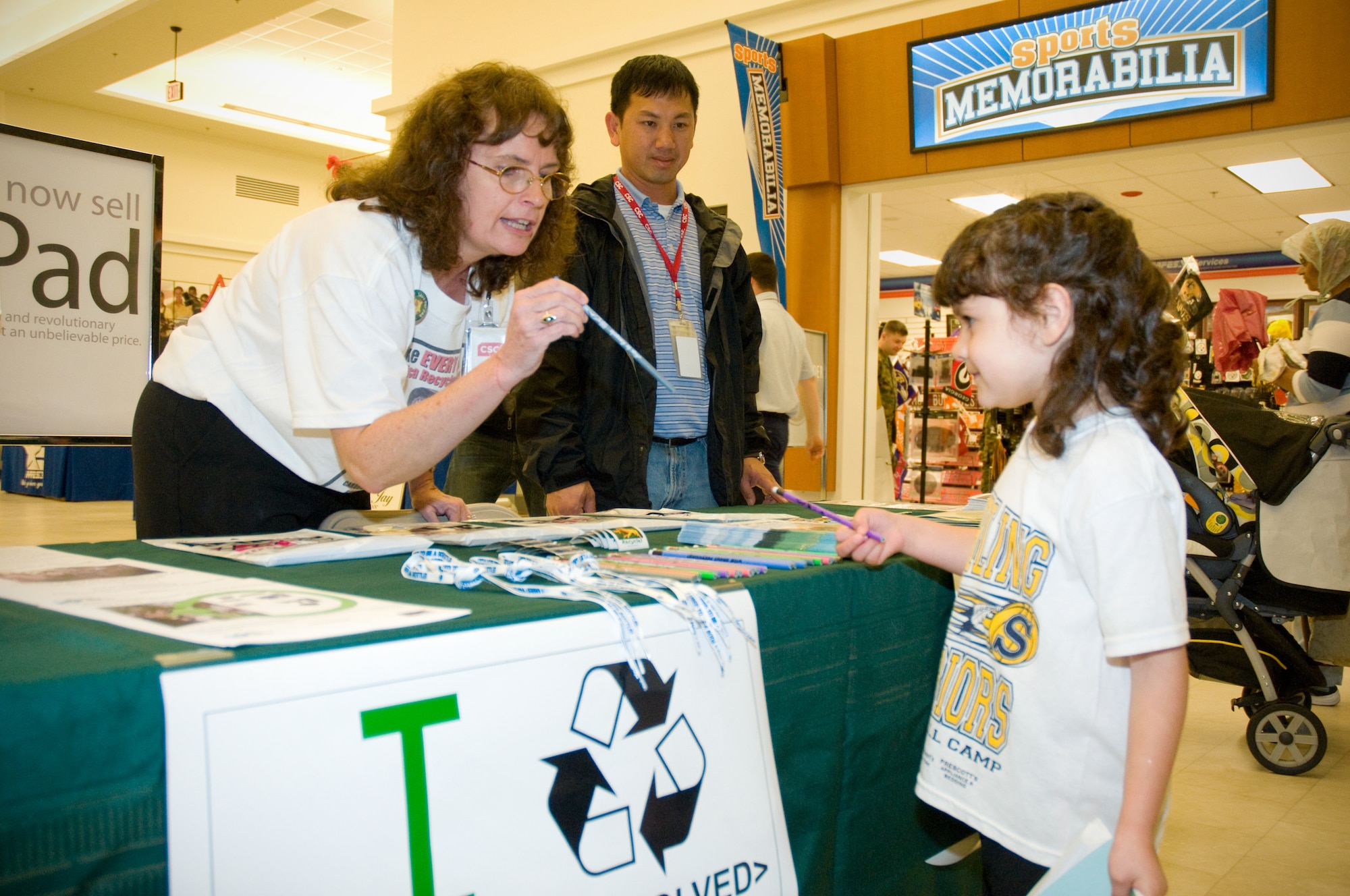 SherrieWatson, left, and Phi Dang from CSC’s environmental office gives pencils and
stickers to 5-year-old Mia Sandoval at the America Recycles Day information booth
at the base exchange Nov. 15. Mia and her mom, Melissa Sandoval, are from Sterling, Ill. Ms. Sandoval’s brother is retired Petty Officer 1st Class Michael Shipman. The booth collected donations for the Cell Phones for Soldiers program that uses proceeds from recycling old cell phones to buy calling cards for deployed troops. The office also sponsored a universal waste turn in for base organizations. (U.S. Air Force photo by Adam Bond)