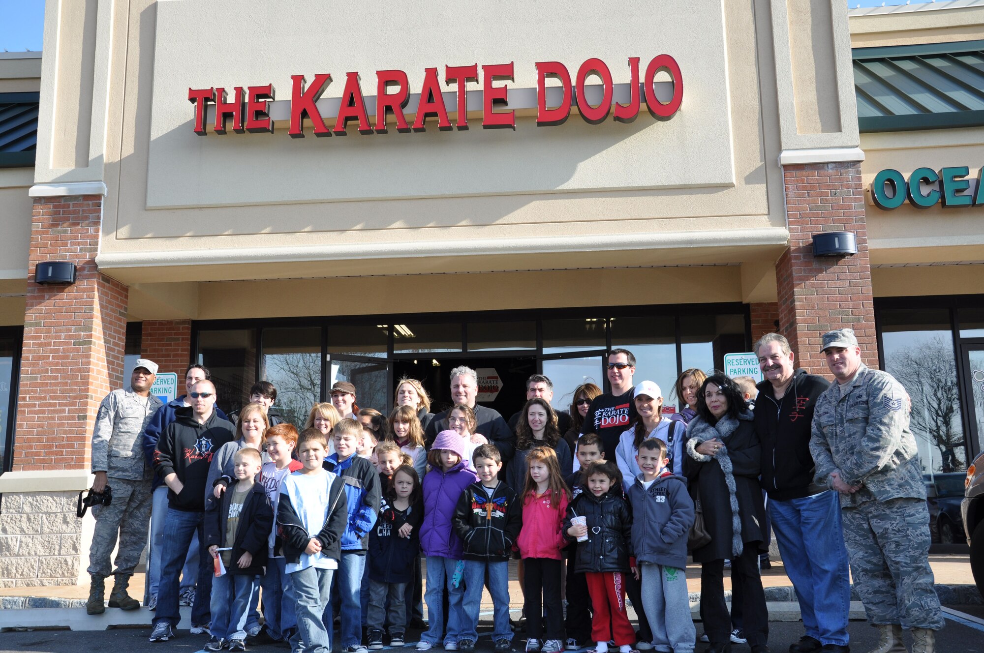 JOINT BASE MCGUIRE-DIX-LAKEHURST, N.J. -- Students, parents and owners of The Karate Dojo in Jackson, N.J., pose with Air Force Reserve Airmen and Family Readiness staff after loading more than 40 turkey meals for delivery to the local base. For the past three years the students have raised money to purchase all the makings for a complete Thanksgiving Day meal to donate to Airmen serving with the 514th Air Mobility Wing at Joint Base McGuire-Dix-Lakehurst, N.J. (U.S. Air Force photo/Master Sgt. Donna T. Jeffries)