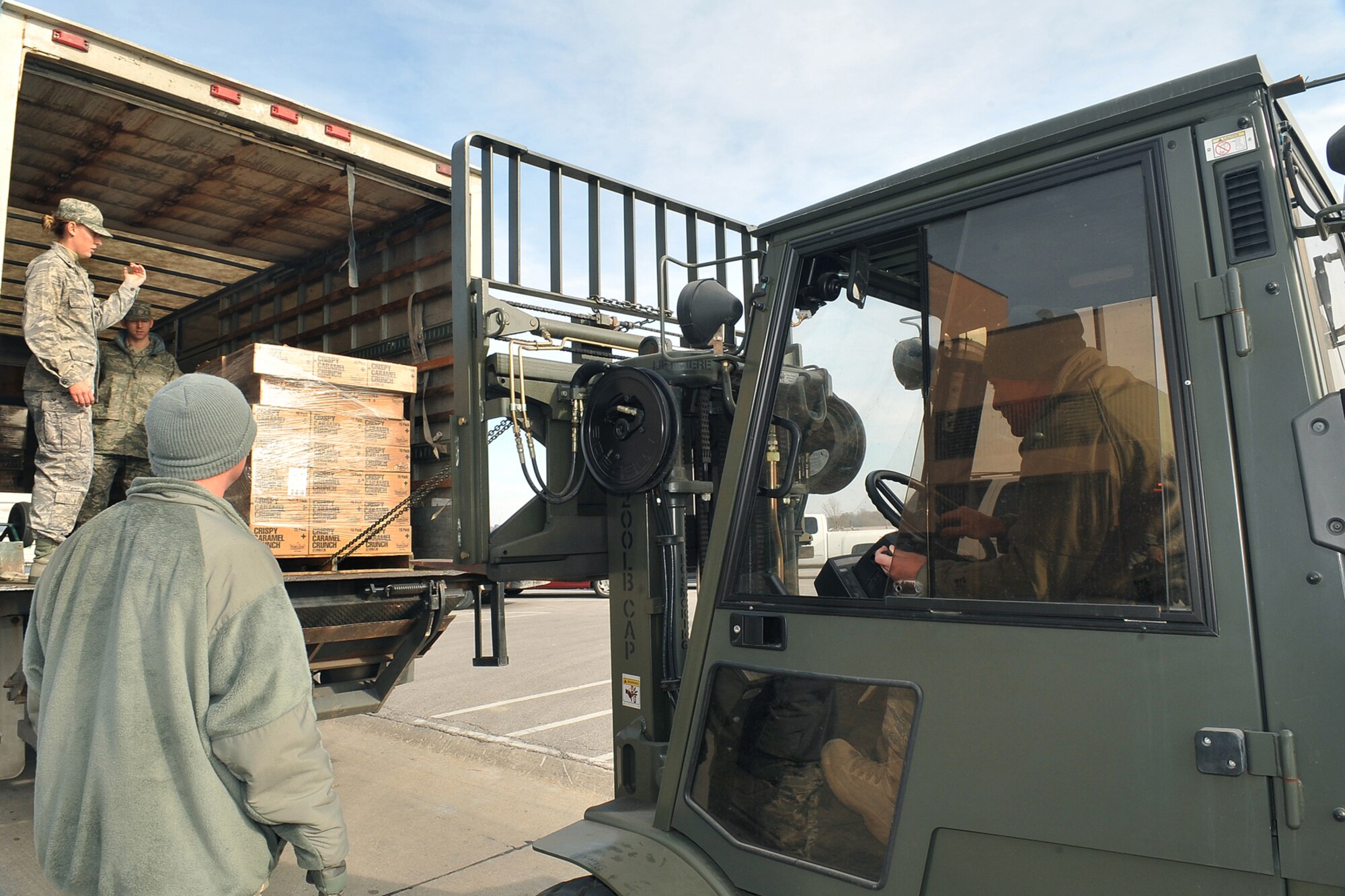 OFFUTT AIR FORCE BASE, Neb. - 1st Lieutenant Robyn Thome, 55th Wing Protocol, helps direct Technical Sgt. Timothy Lawrence, 55th Force Support Squadron, as he moves a pallet of popcorn outside the Martin Bomber Building Nov. 18. U.S. Air Force Photo by Charles Haymond (Released)