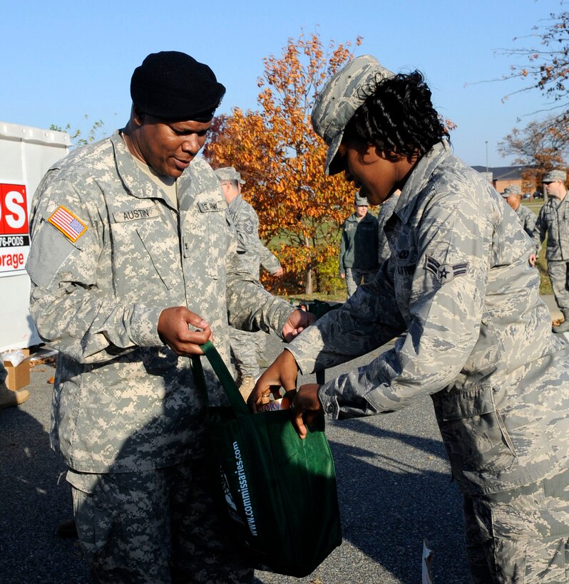 LANGLEY AIR FORCE BASE, Va. – Col. Reggie Austin, (left), 633d Air Base Wing vice commander, helps pack canned goods with Airman 1st Class Tawanda Hedrick, 710th Combat Operations Squadron imagery analysis, during the Operation Warm Heart basket build, Nov. 23. Operation Warm Heart receives, manages and distributes charitable funds to Langley Air Force Base families.  This year’s basket build up directly contributed more than 400 baskets of complete Thanksgiving meals for Airmen and their families that could use help during the holidays. (U.S. Air Force photo/Staff Sgt. Dana Hill) (RELEASED)  