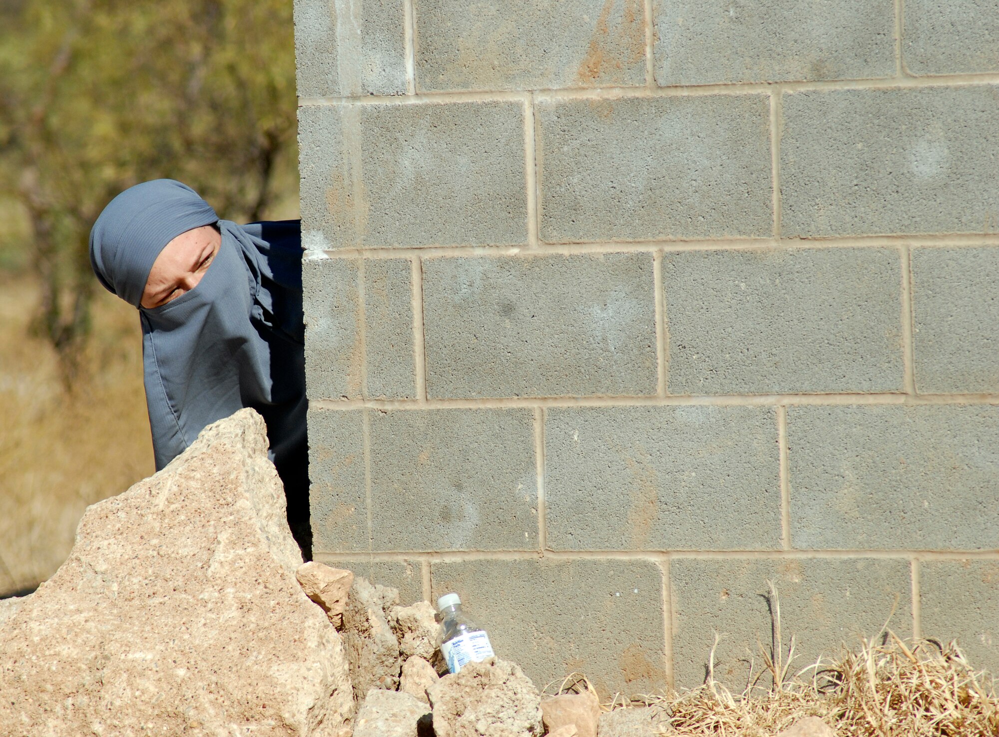 GOODFELLOW AFB, Texas – A member of the 344th Military Intelligence Battalion acting as an Afghani role player takes cover during a training scenario at a mock Afghanistan village.  The 344th MIB took time to show visitors some of the possible situations they may encounter while deployed to Afghanistan during the annual Goodfellow Community Appreciation Day Nov. 20.  Goodfellow opened its doors for the day to allow the local community the opportunity to get a glimpse of the vital mission that the base performs.  (U.S. Air Force photo/Master Sgt. Randy Mallard)