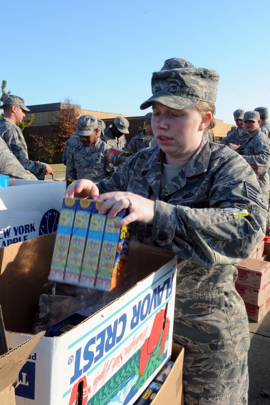 LANGLEY AIR FORCE BASE, Va – Staff Sgt. Erin Scheel, product reporter with the 30th Intelligence Squadron, unpacks food from the boxes so it can be distributed to Airmen across base Nov. 23. During Operation Warm Heart, Team Langley builds 350 complete Thanksgiving meals for Airmen in need during the holiday season. In addition, the surplus supplies are donated to the local community and the Foodbank of the Virginia Peninsula. (U.S. Air Force photo/Airman 1st Class Racheal Watson)(RELEASED)  