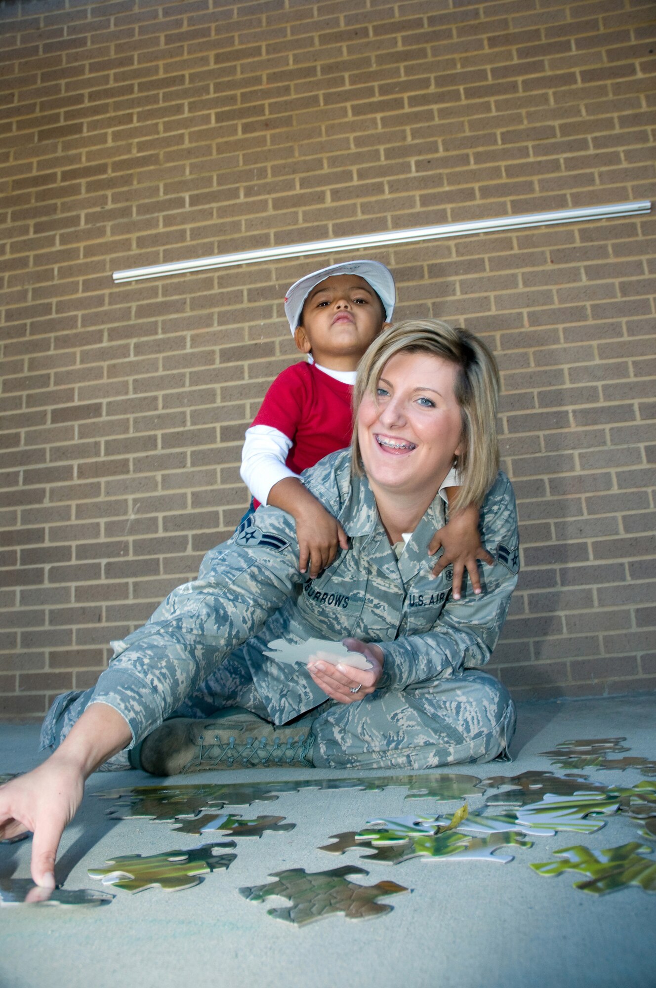 Three-year-old Christian Threatt hugs his mom, Airman 1st Class Melissa Burrows,
81st Medical Operations Squadron, as they work on a puzzle. (U.S. Air Force photo by Adam Bond)