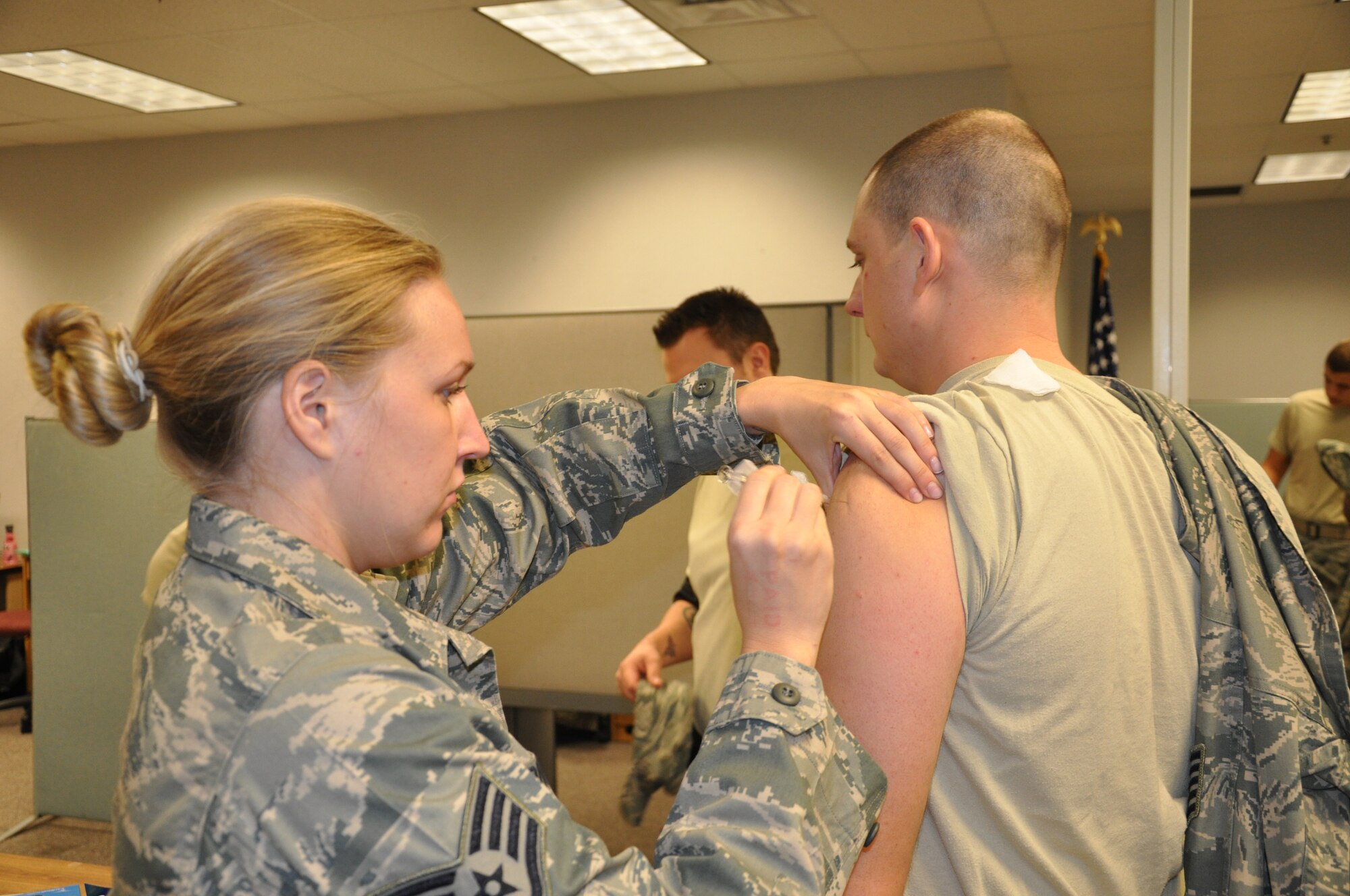 WRIGHT-PATTERSON AIR FORCE BASE, Ohio – Tech. Sgt. Brian Phillips, 445th Aircraft Maintenance Squadron, receives his annual flu shot from Staff Sgt. Danitra Brown, 445th Aerospace Medicine Squadron, during the Nov. 20 unit training assembly.  (U.S. Air Force photo/Tech. Sgt. Jeremy Caskey)