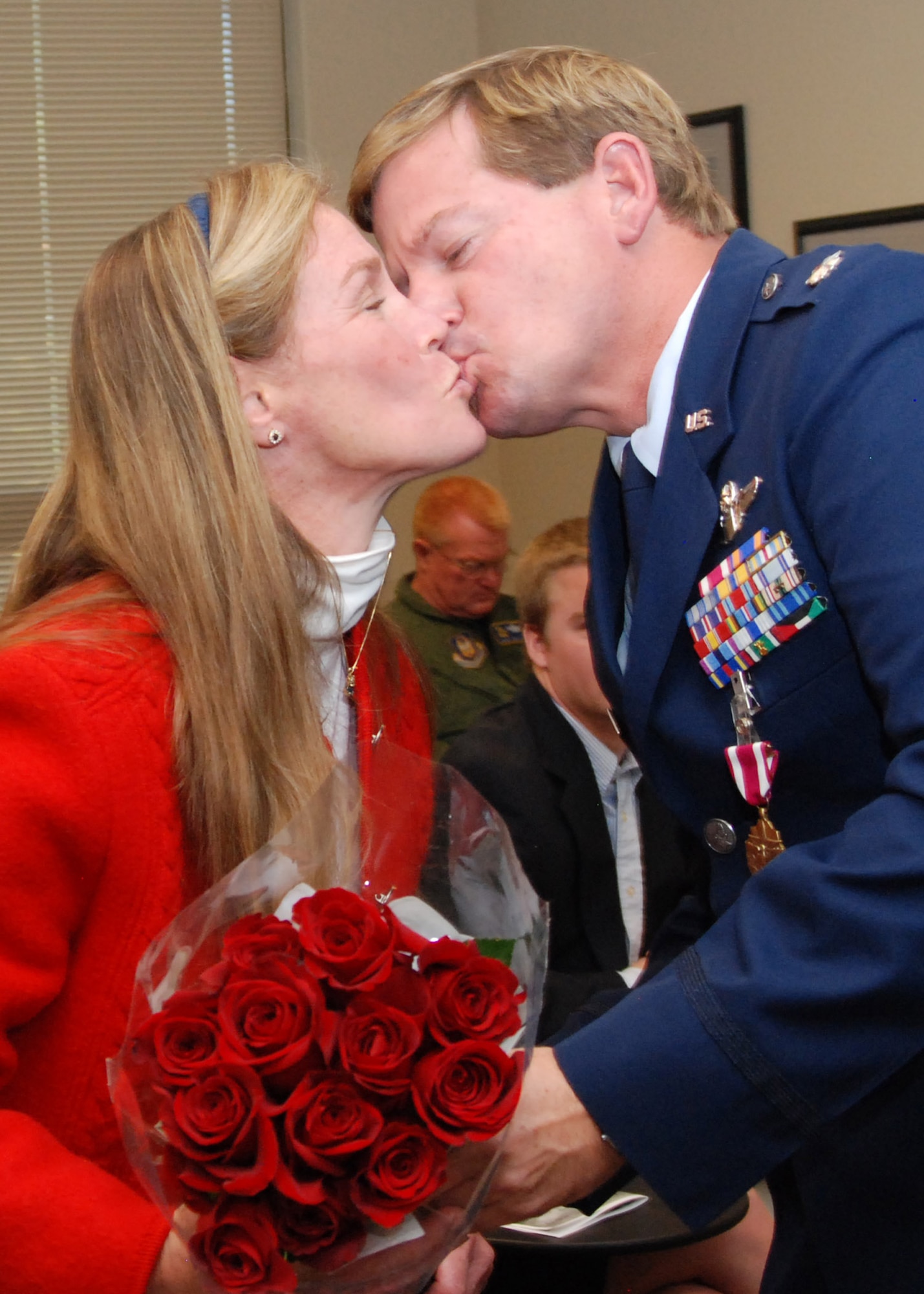 Lt. Col. Mark Ott, 700th Airlift Squadron evaluator and pilot, gives a kiss to his wife Amanda, during his retirement ceremony, for her support during his 32 years of military service Nov. 7.  (U.S. Air Force photo/Master Sgt. Stan Coleman)  