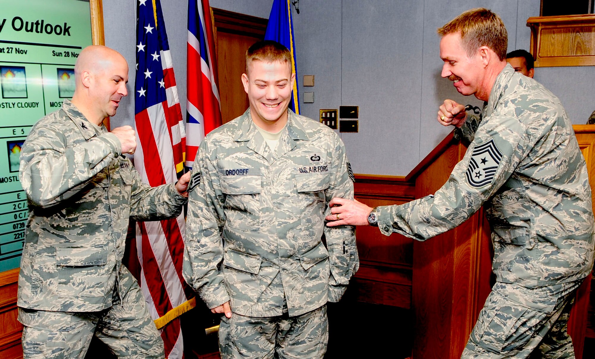 RAF MILDENHALL, England -- Staff Sgt. Matthew Ordorff, 100th Operations Support Squadron weather forcaster, is step promoted by Col. Chad Manske, 100th Air Refueling Wing commander, and Command Chief Master Sgt. Christopher Powell, 100th ARW command chief, at the wing staff meeting Nov. 24, 2010. The weather forecaster said when Colonel Manske and Chief Powell brought out the stripes, he went numb with shock. "Other than getting married, this was the best day of my life so far!" he said. (U.S. Air Force photo/Senior Airman Ethan Morgan)